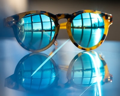 Faherty Original Sunglasses resting on a table with light reflection.