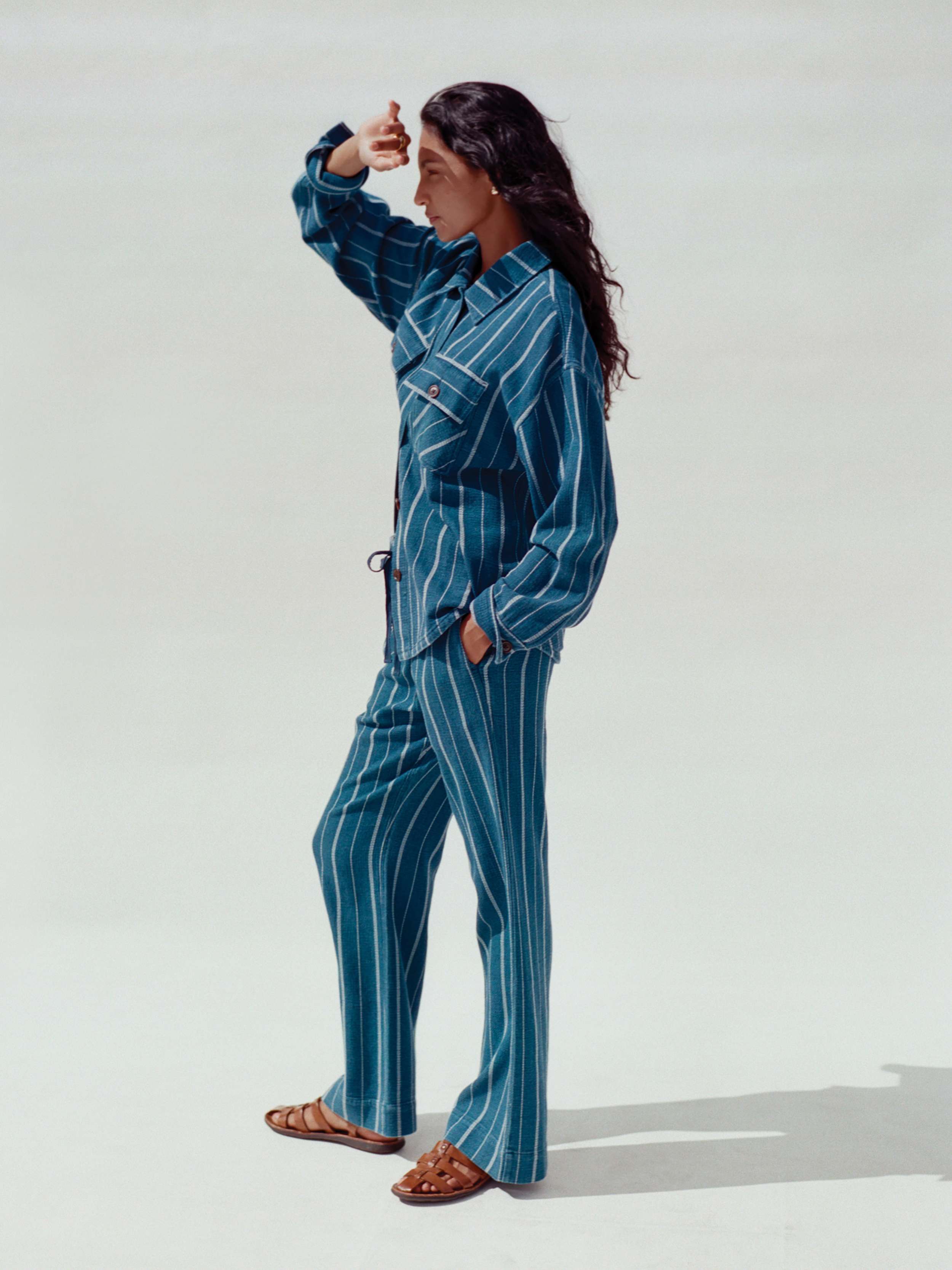 Woman wearing a blue striped top and matching bottom against a white background