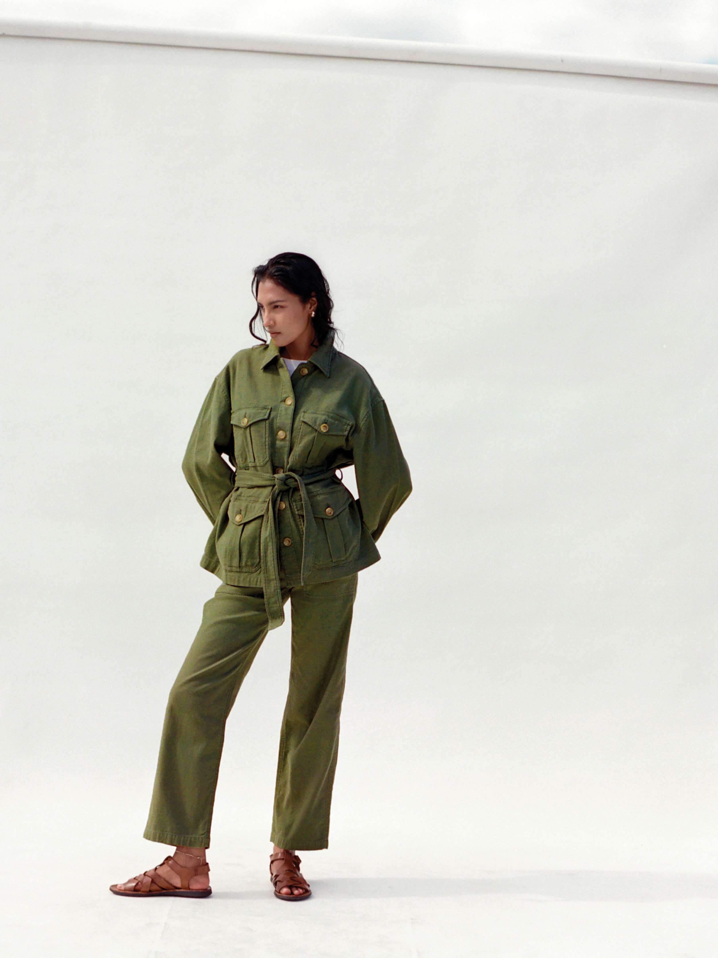 Woman wearing a green jacket and matching pants against a white background