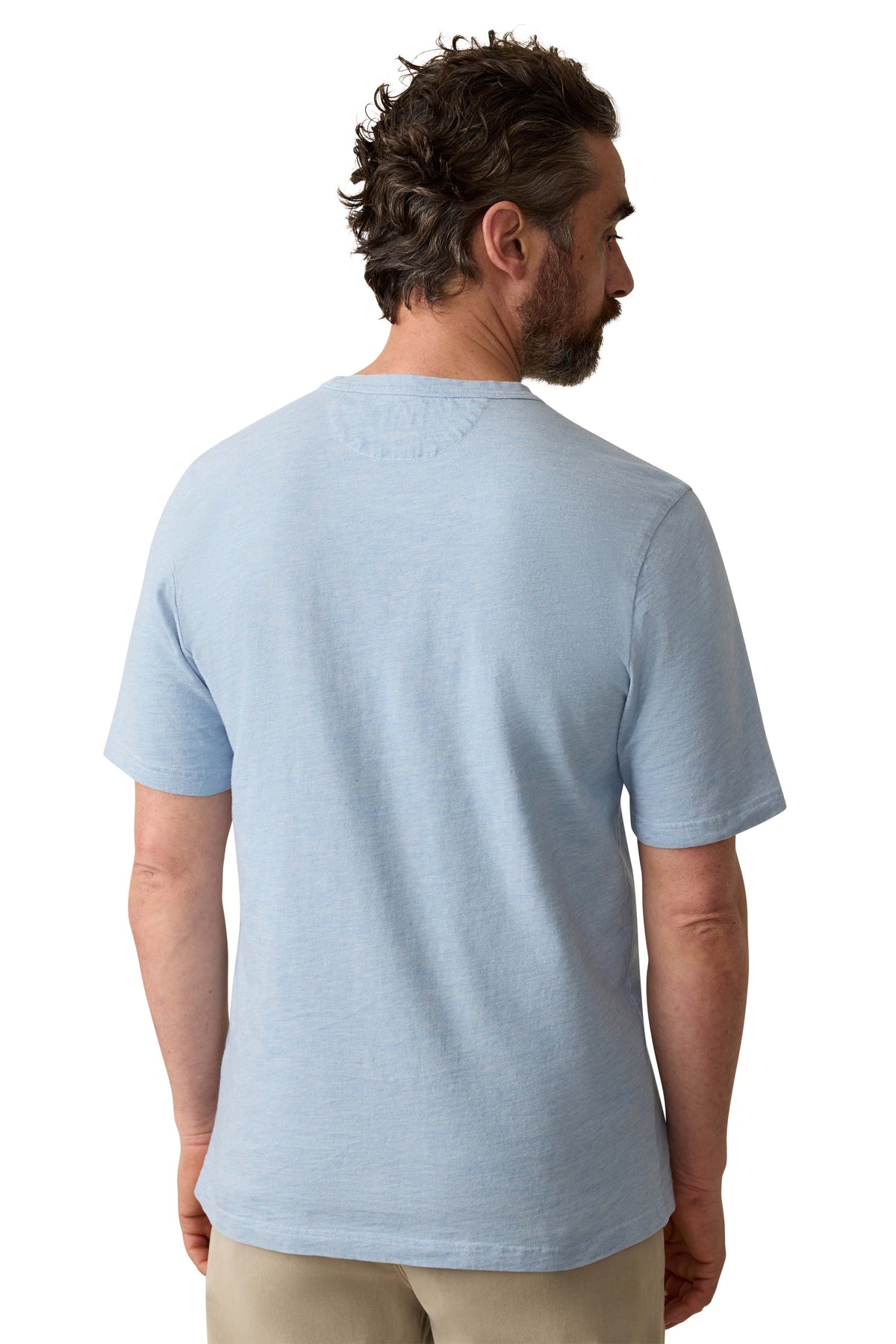 A man viewed from behind wearing a blue tee and beige pants, image 3 of 3