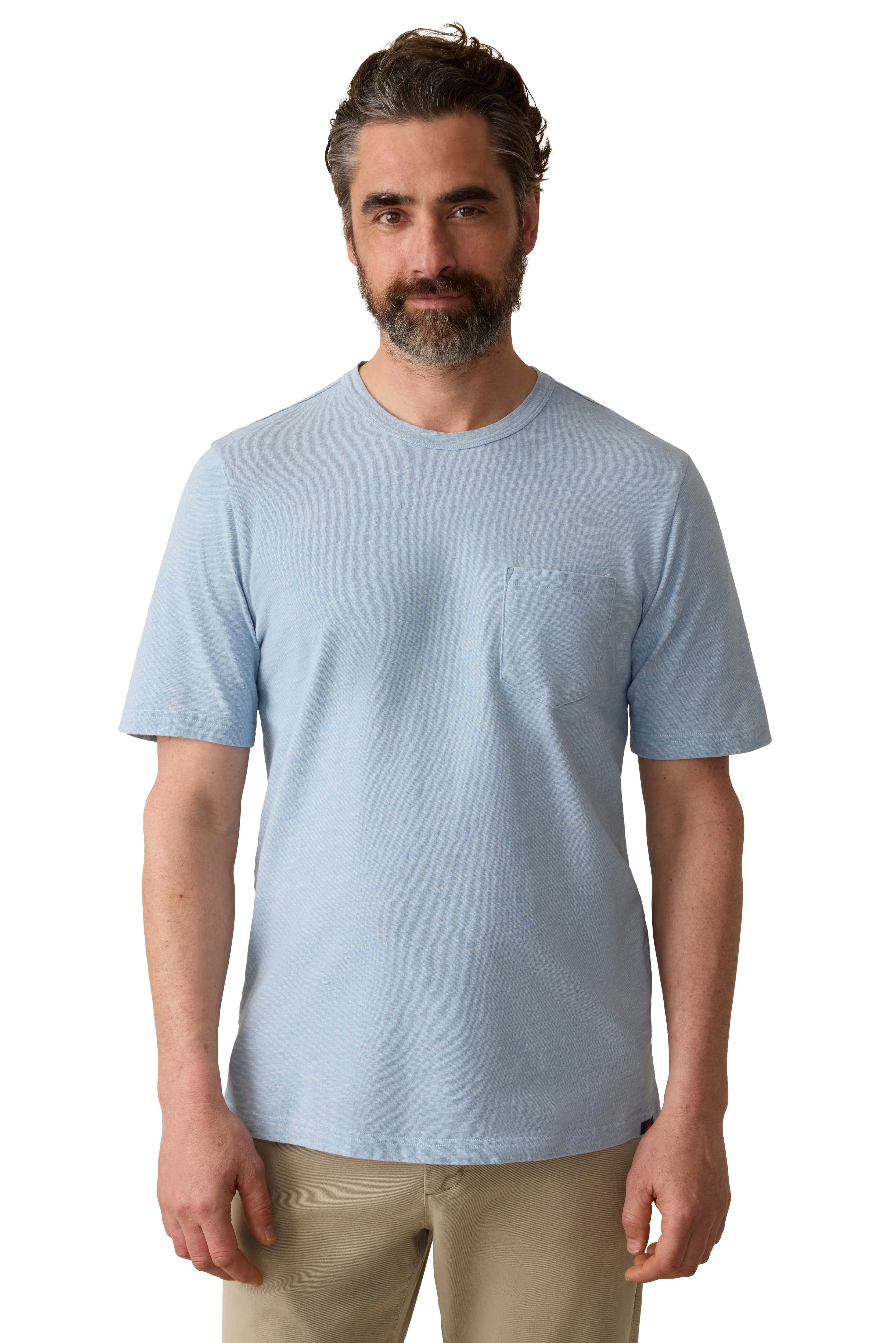 A man wearing a blue tee and beige pants