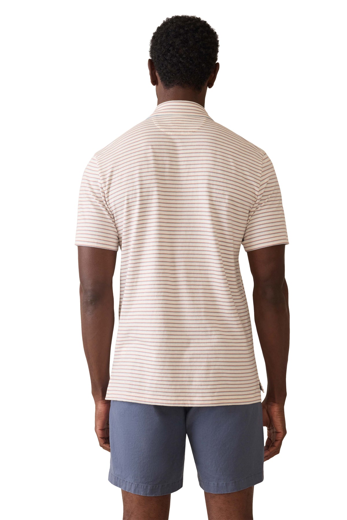 A man viewed from behind wearing a striped polo shirt and blue shorts, image 3 of 3