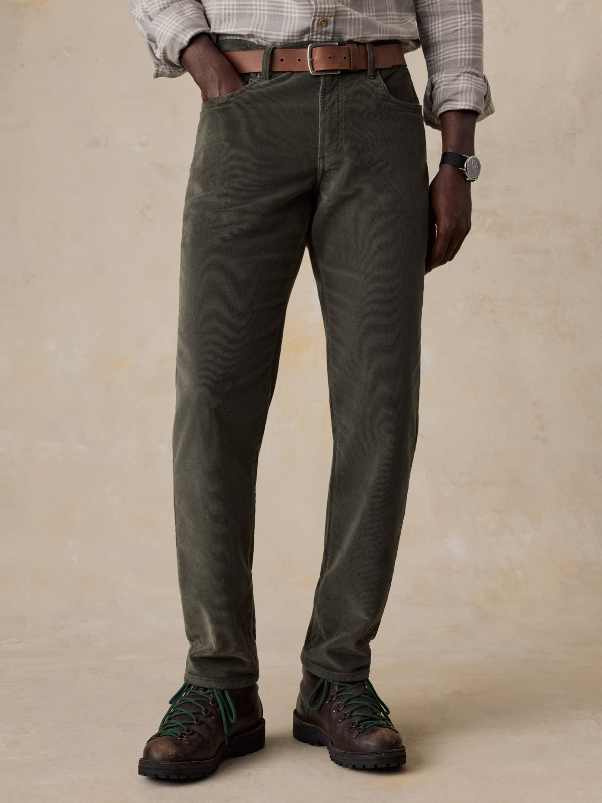 A man wearing green corduroy pants with a plaid button shirt , image 2 of 5