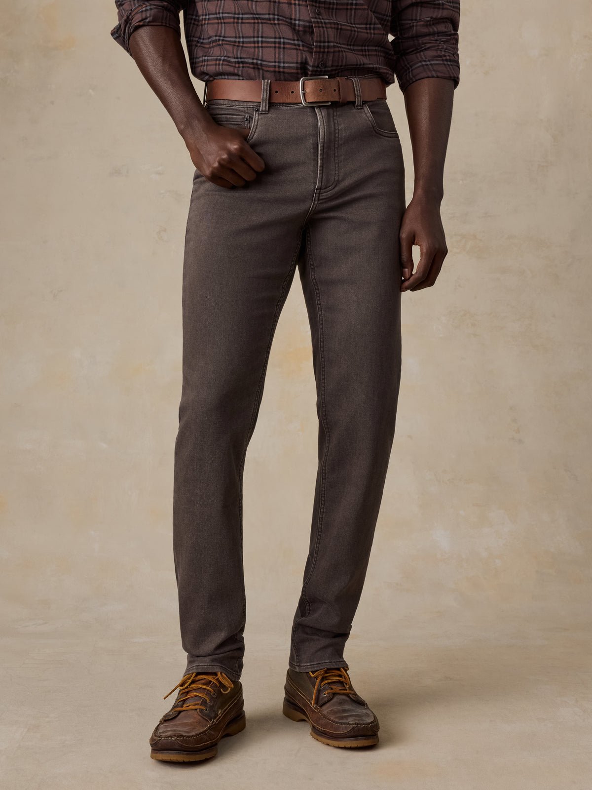 Man wearing a brown plaid shirt and brown pants, image 2 of 5