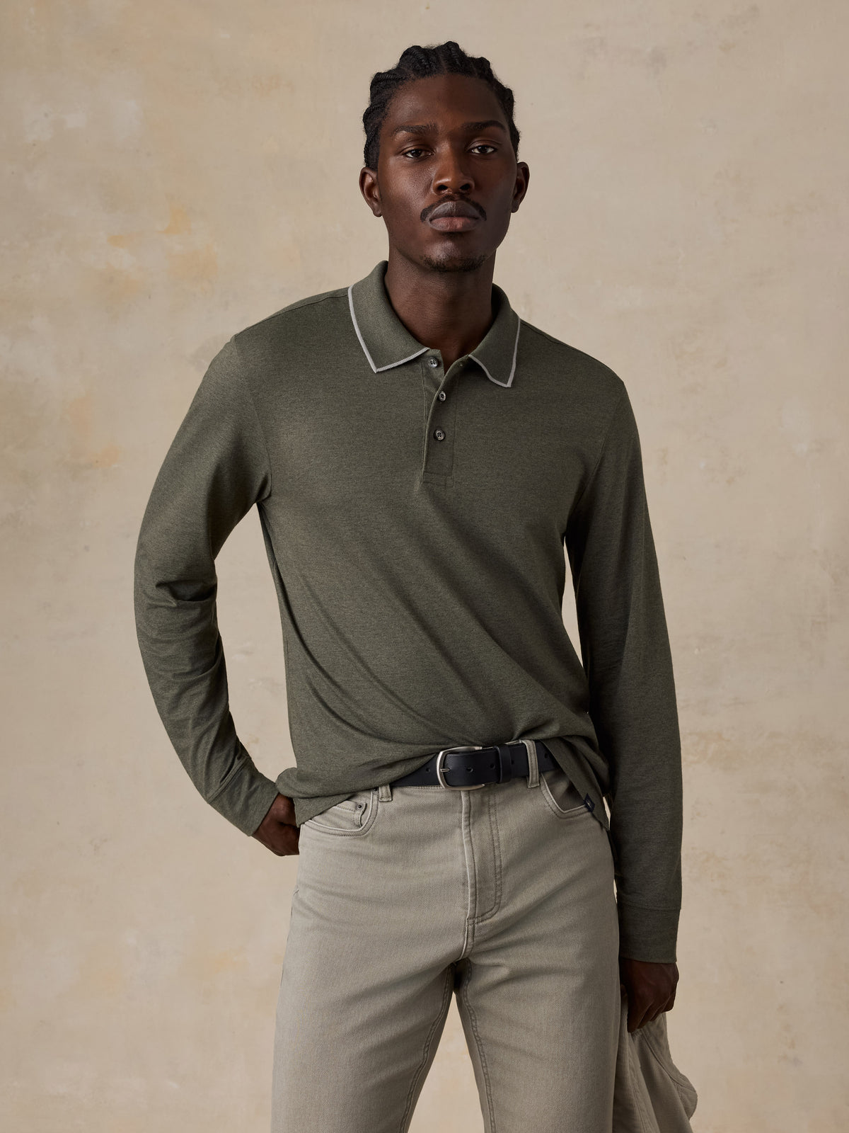 A man wearing a green long sleeve polo with green pants, image 2 of 6