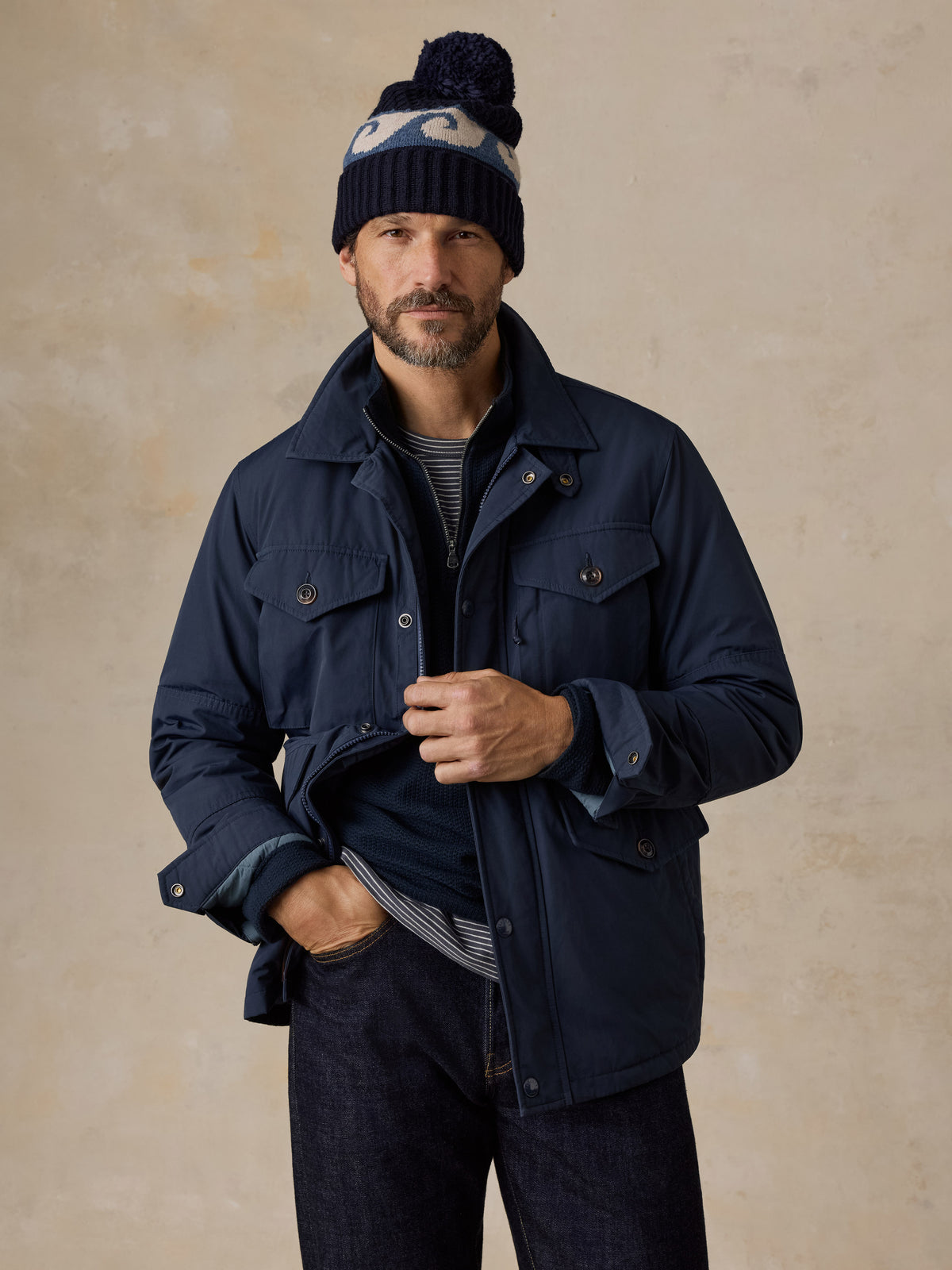 A man wearing a blue jacket and blue jeans, image 1 of 5