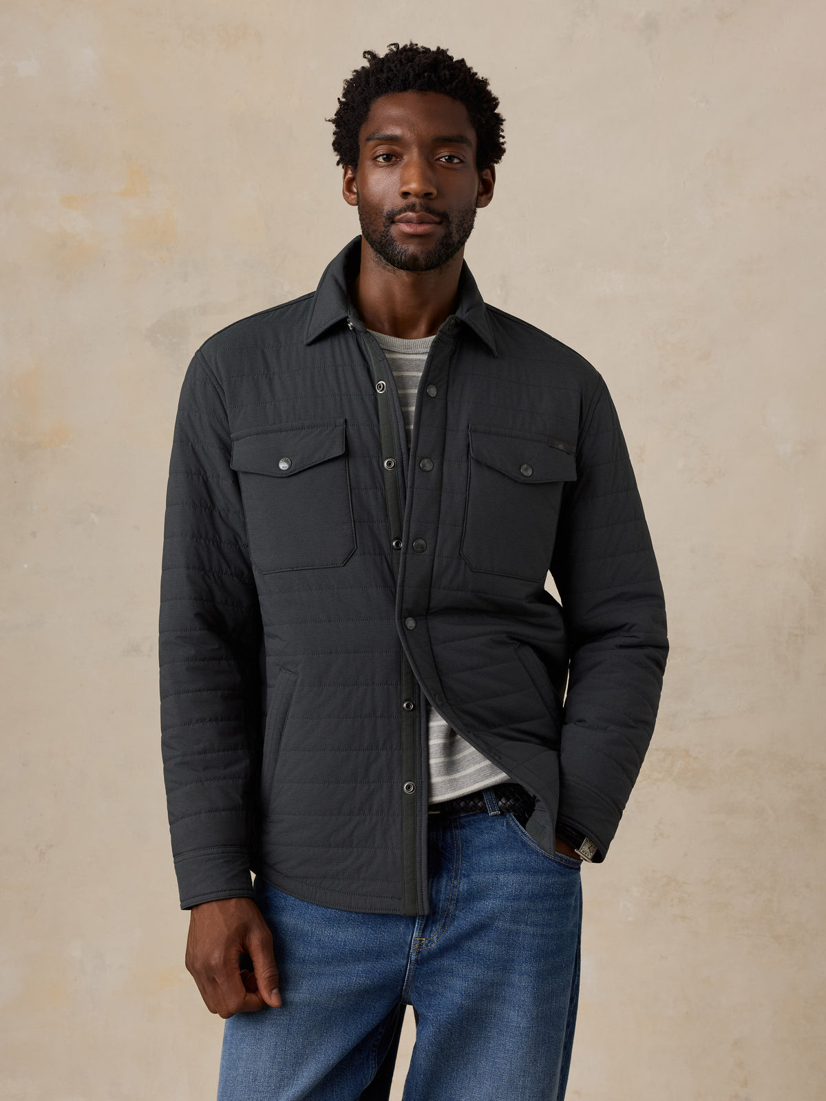 A man wearing a black jacket and jeans, image 2 of 4