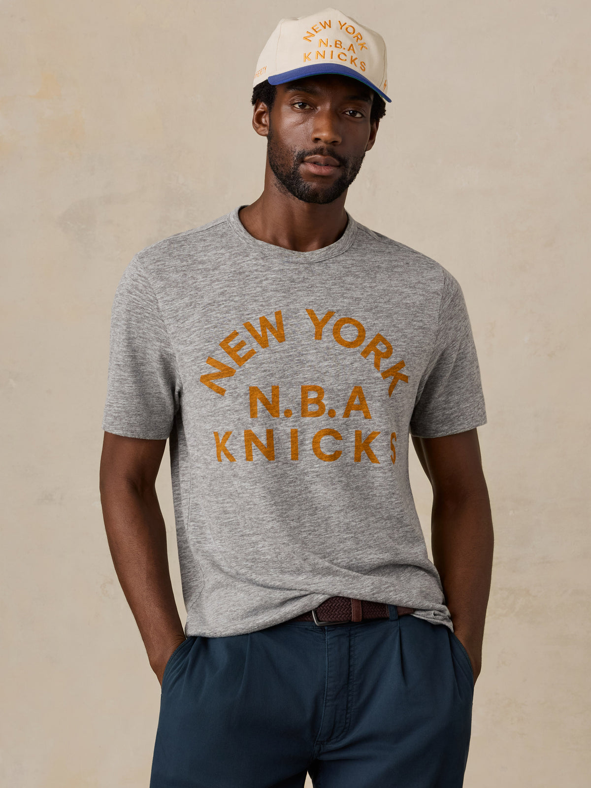 A man wearing a grey NY Knicks tee, image 1 of 6