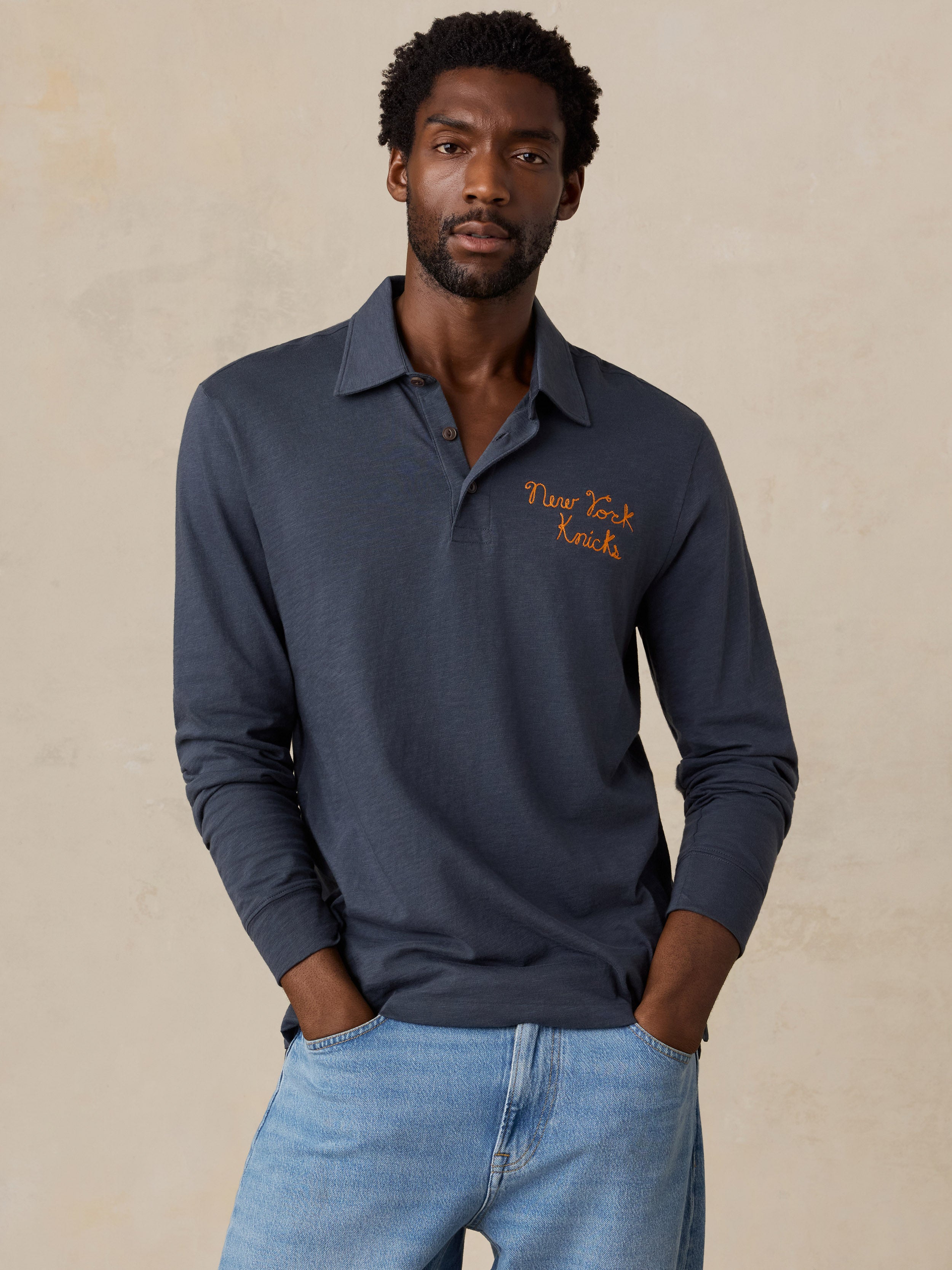 A man wearing a blue NY Knicks polo shirt