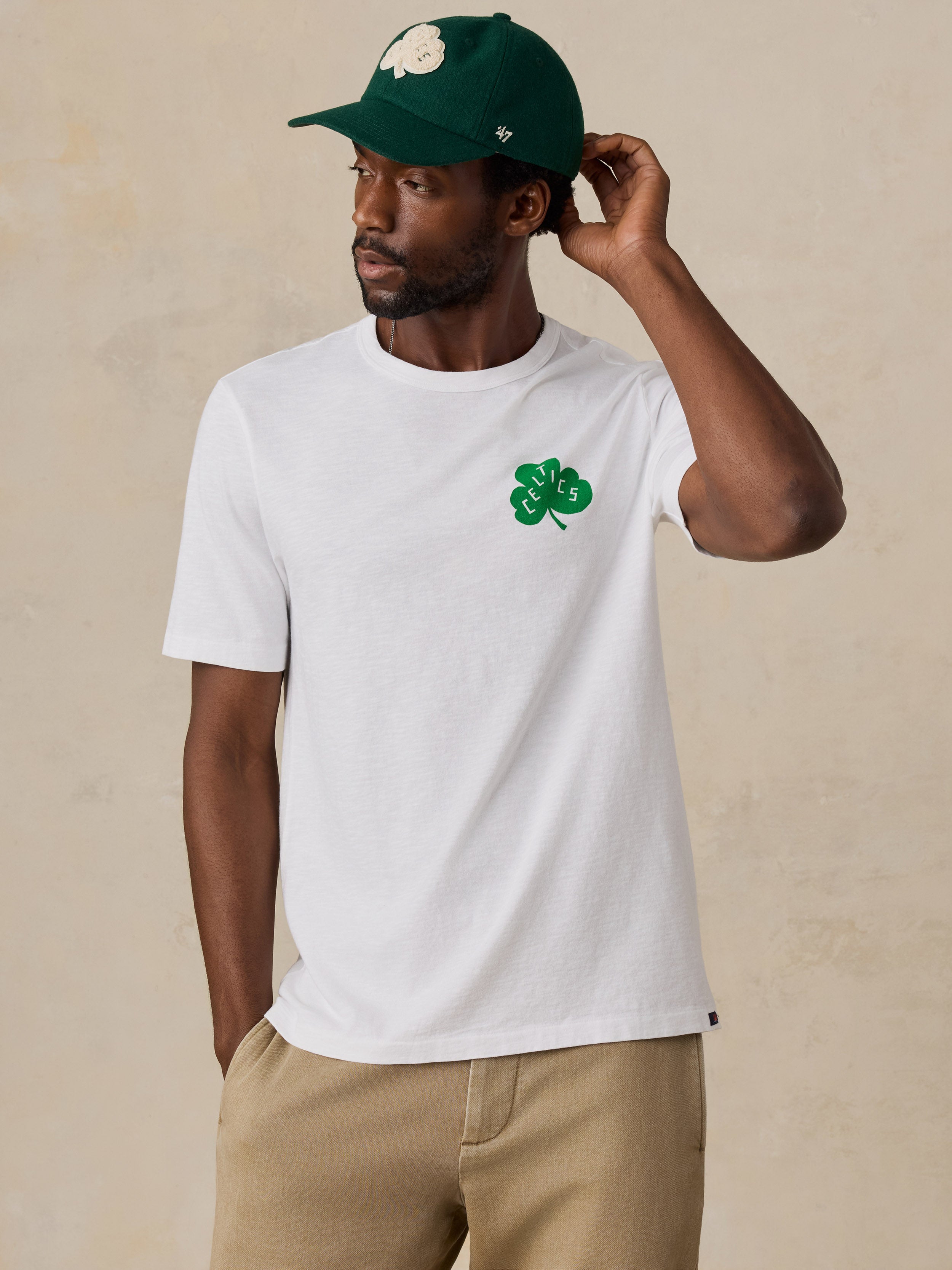 A man wearing a white Boston Celtics tee and hat