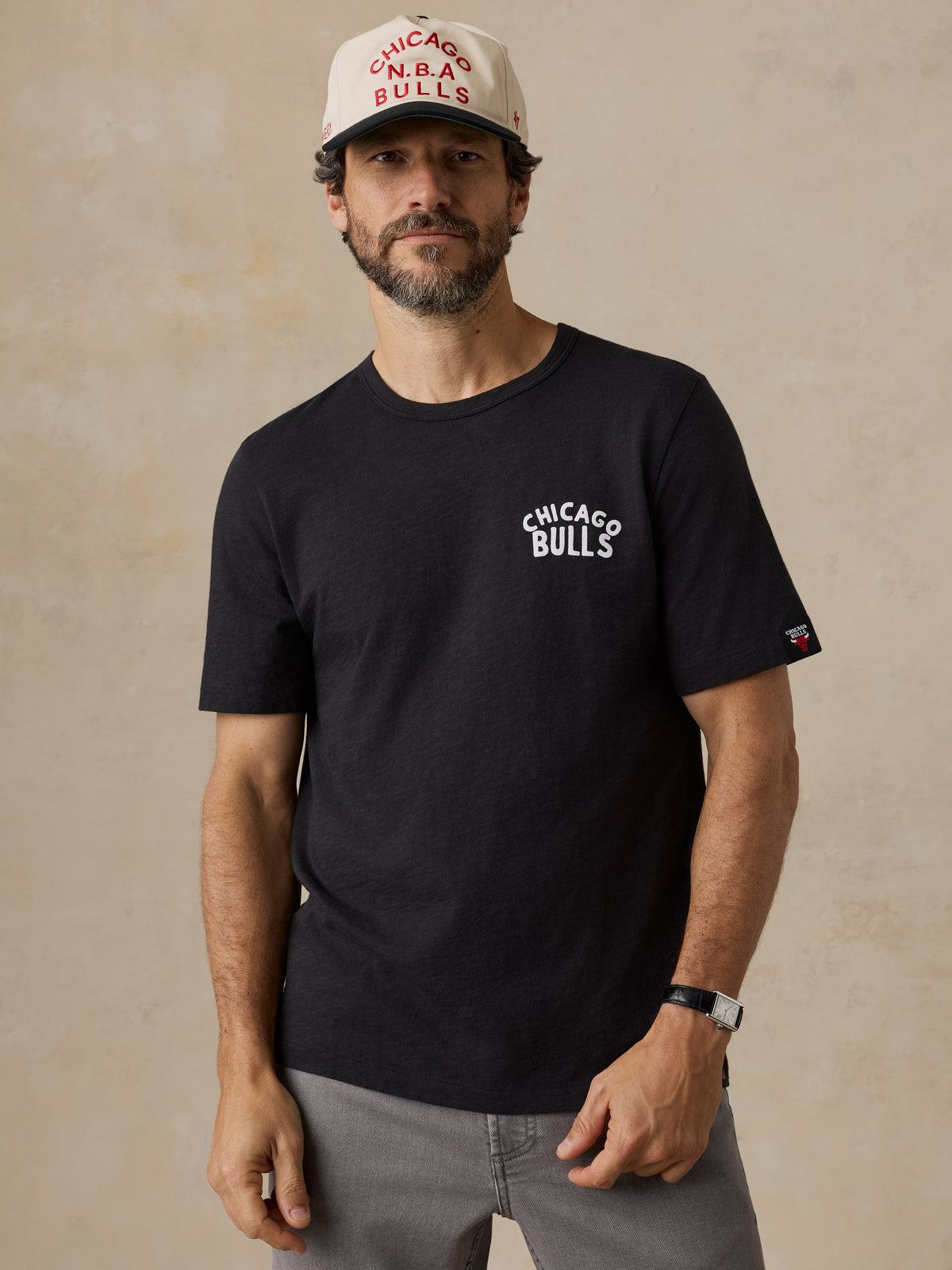 A man wearing a black Chicago bulls tee and hat, image 1 of 6