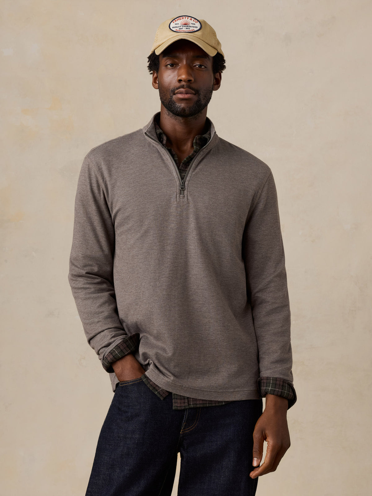 A man wearing a light brown quarter zip, image 1 of 5