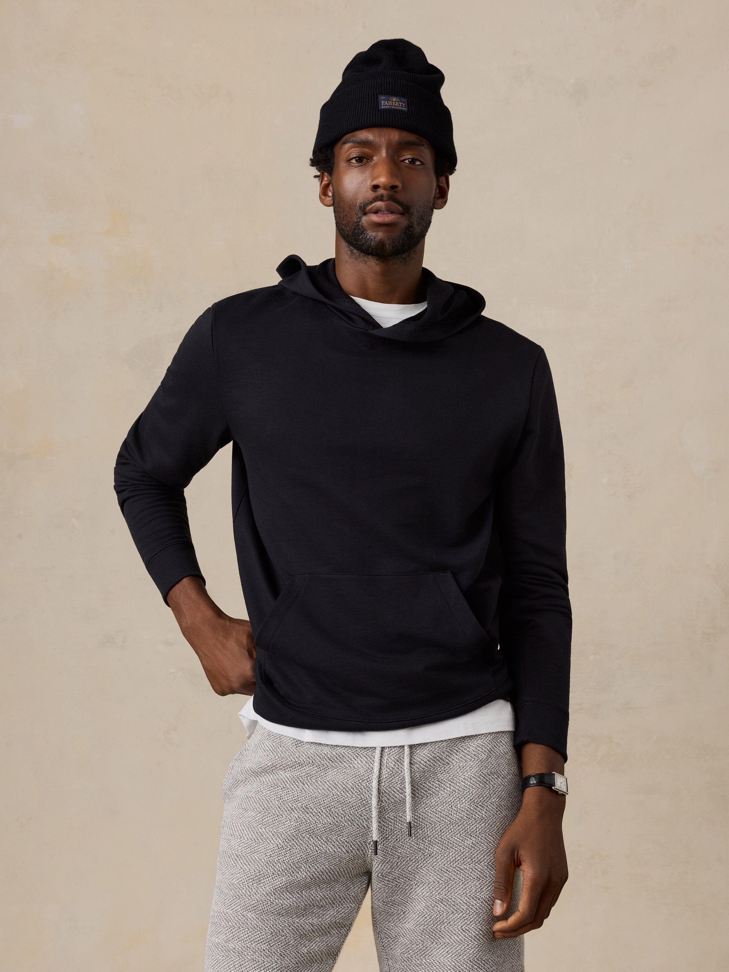 A man wearing a black hoodie and lounge shorts
