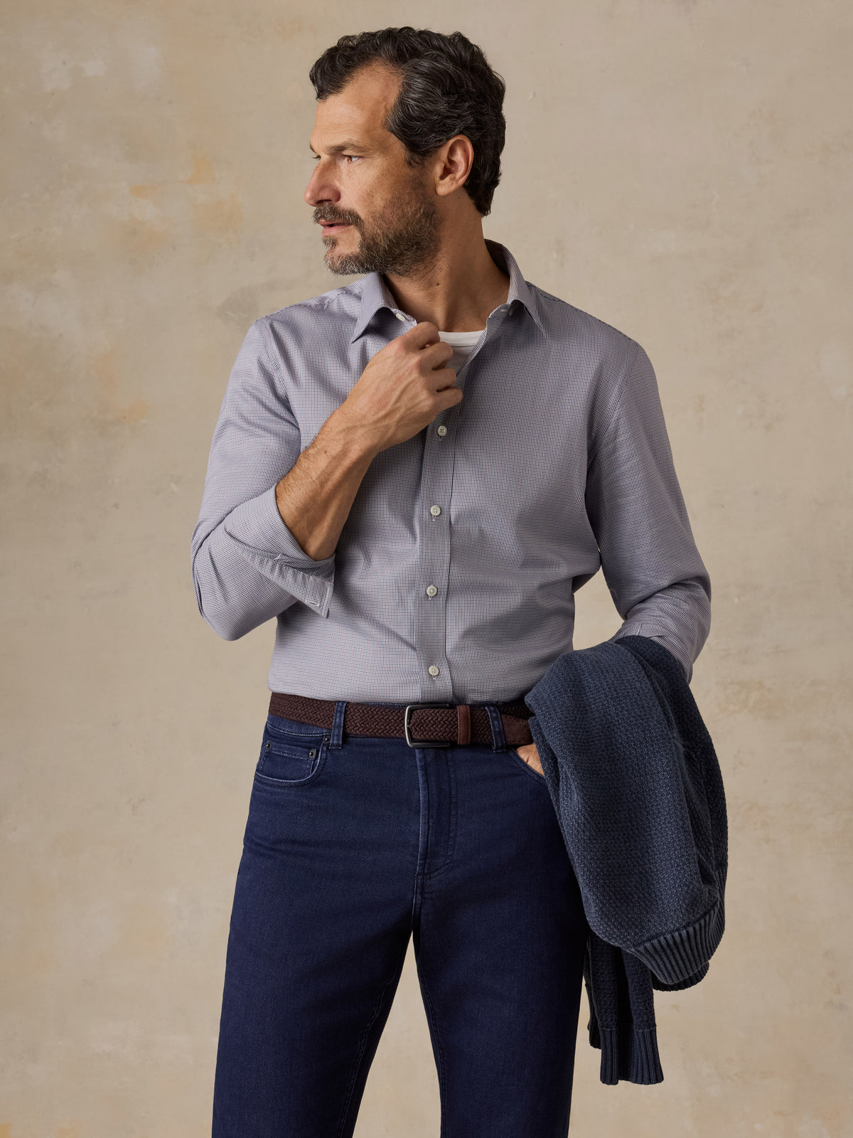 A man wearing a blue button up shirt and blue jeans, image 1 of 5