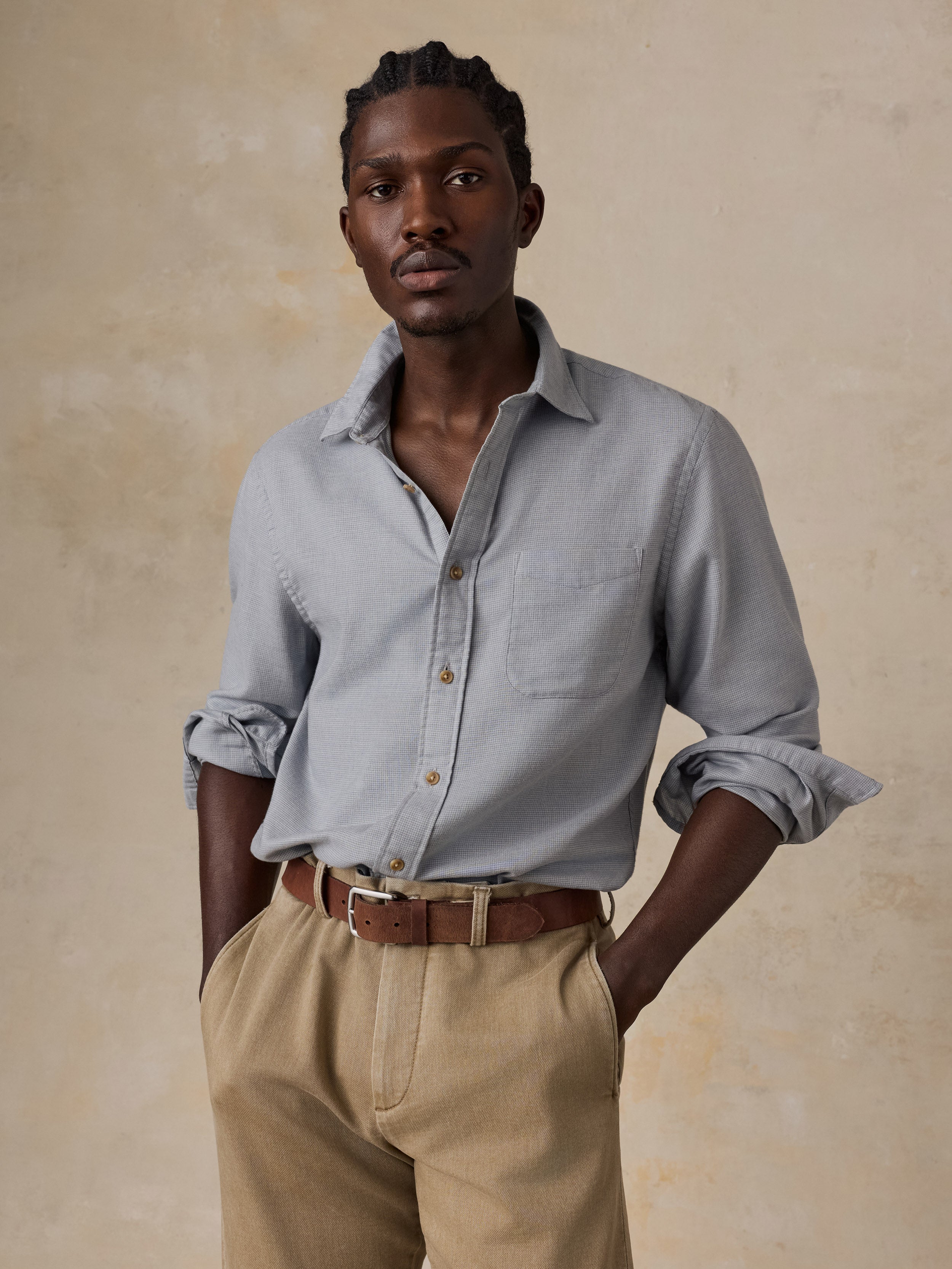 A man wearing a grey shirt and beige pants