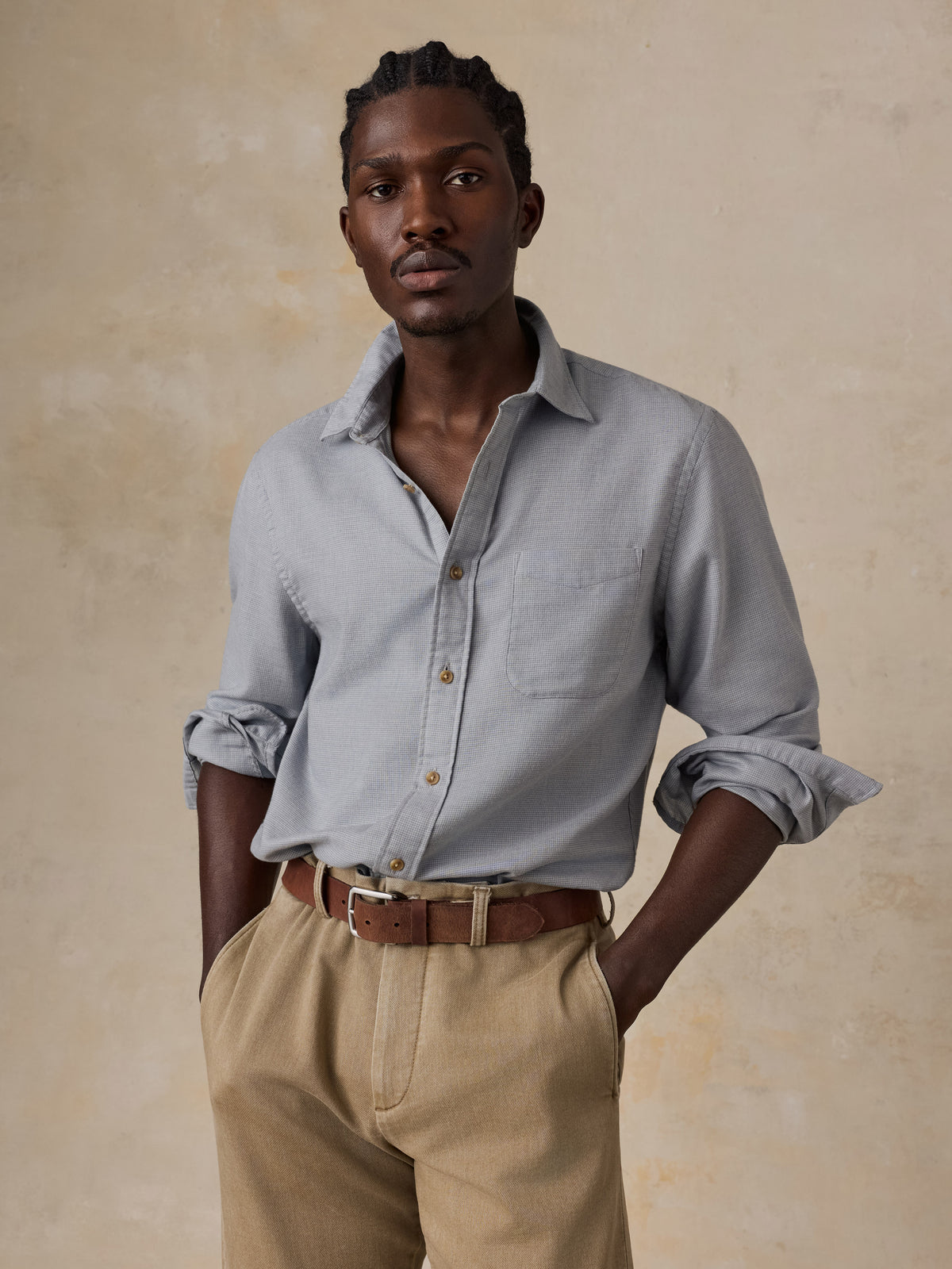 A man wearing a grey shirt and beige pants, image 1 of 5
