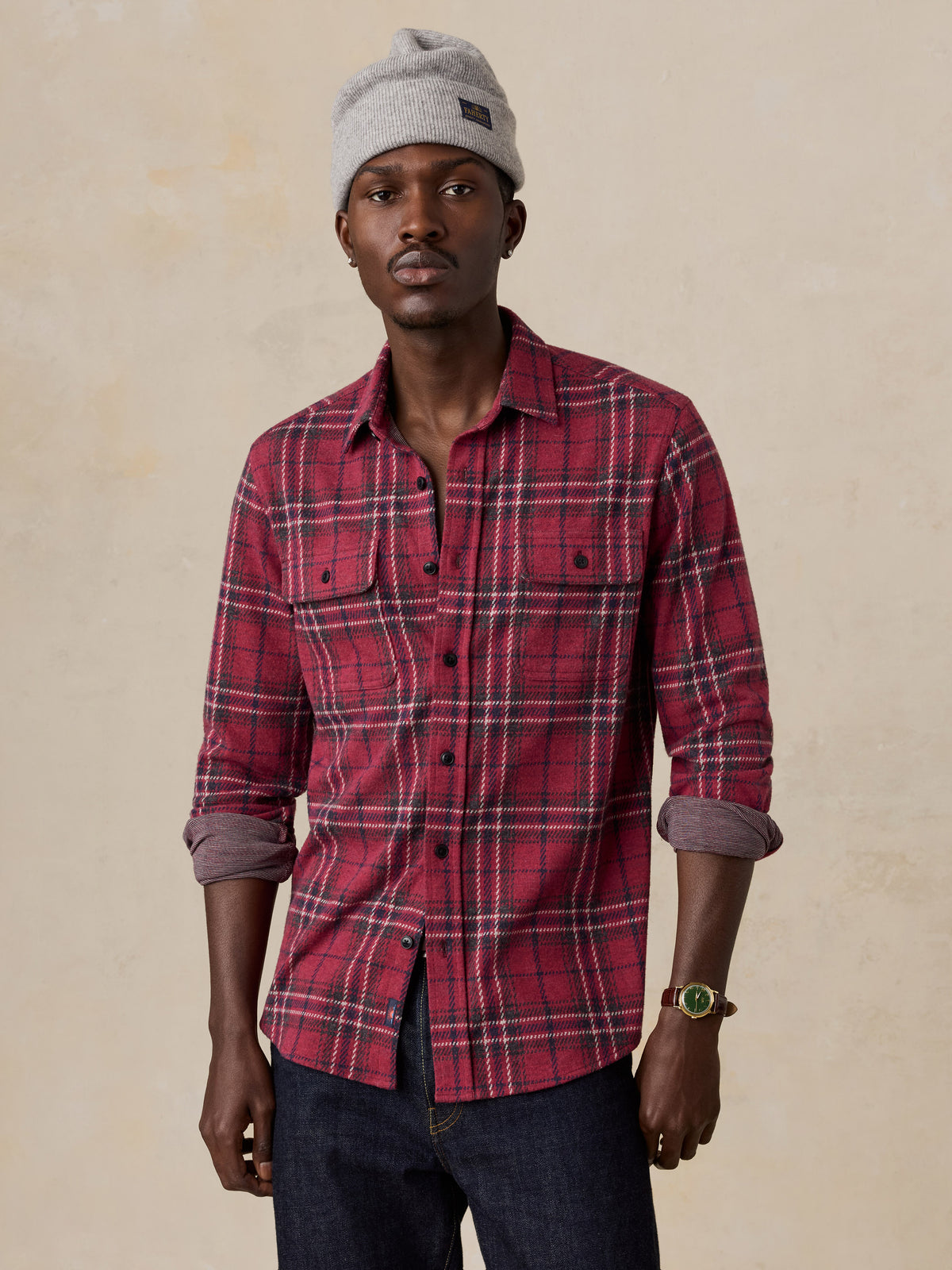 A man wearing a red button up shirt and a grey beanie, image 1 of 6