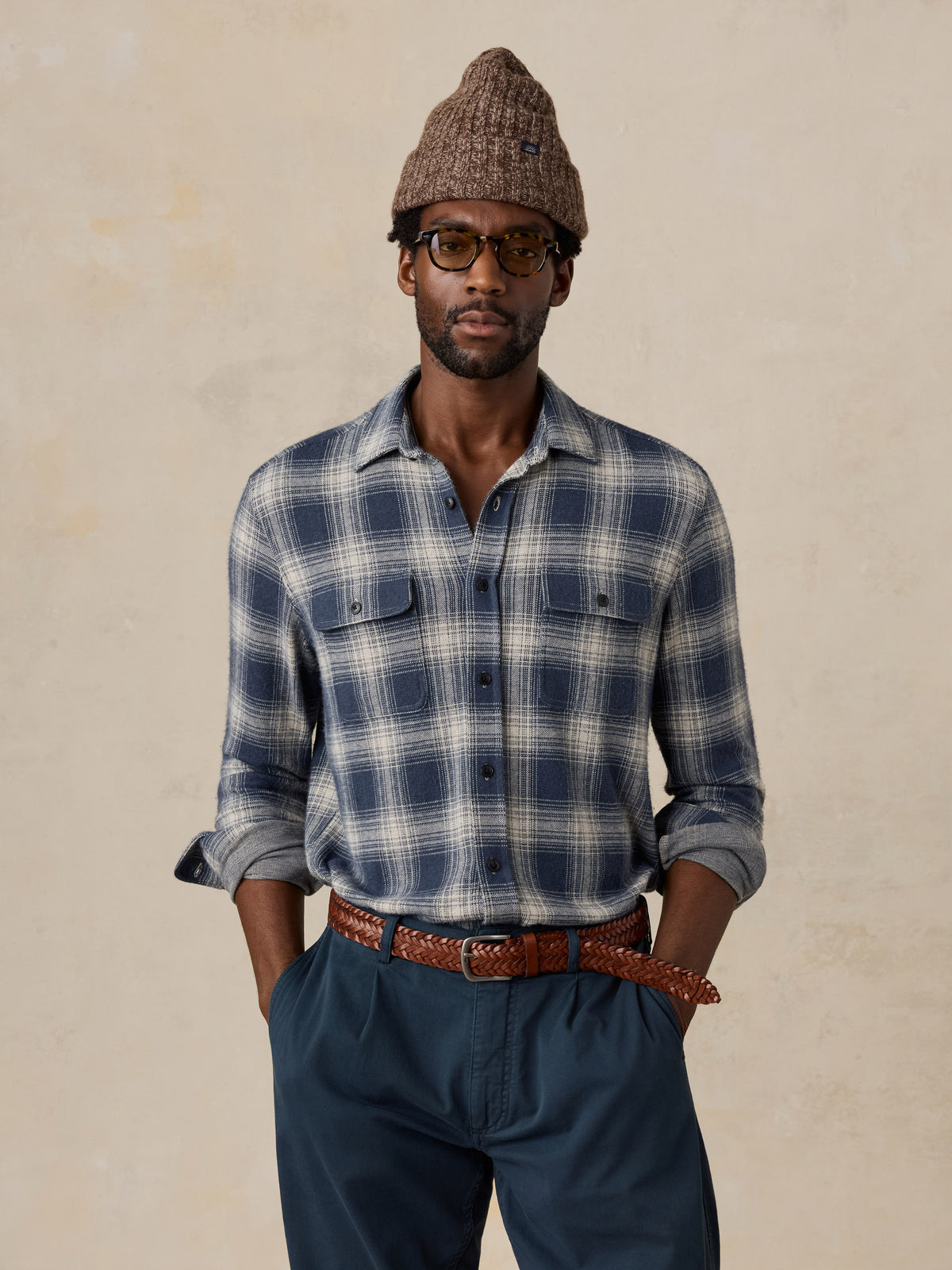 A man wearing a blue button up shirt and a brown beanie, image 1 of 5