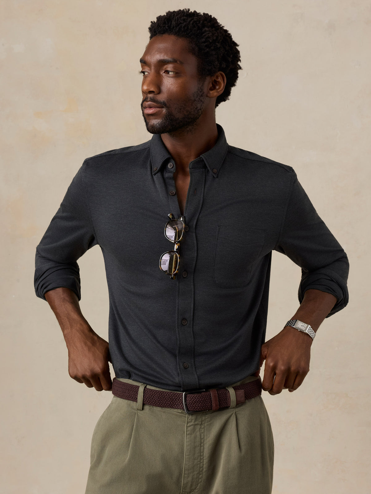 A man wearing a black shirt and green pants, image 6 of 6