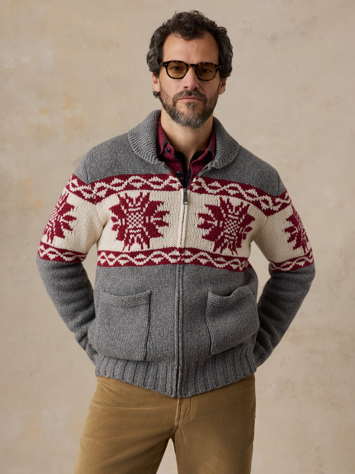 A man wearing a printed wool cardigan and tan pants, image 2 of 5