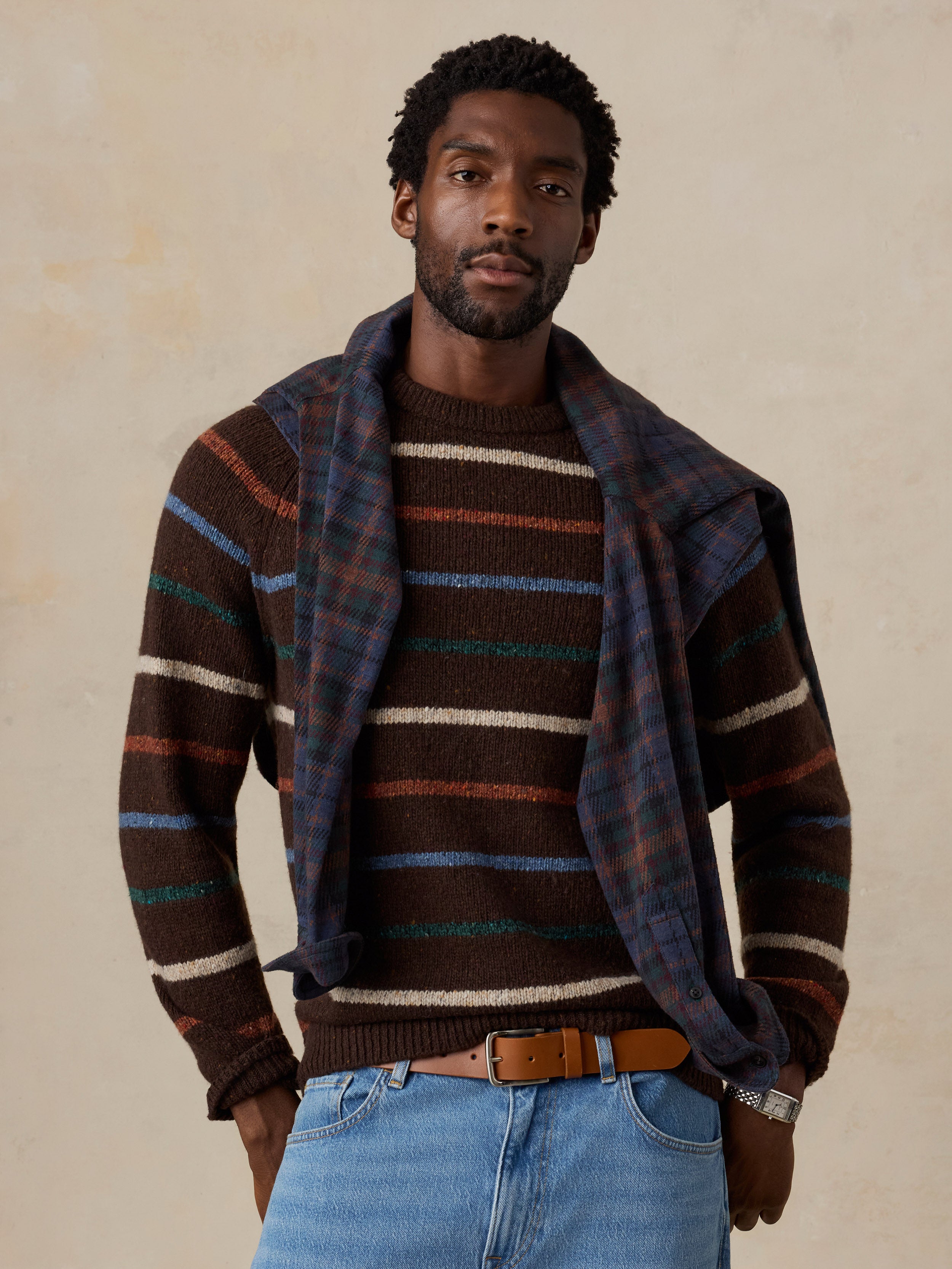 A man wearing a brown striped sweater