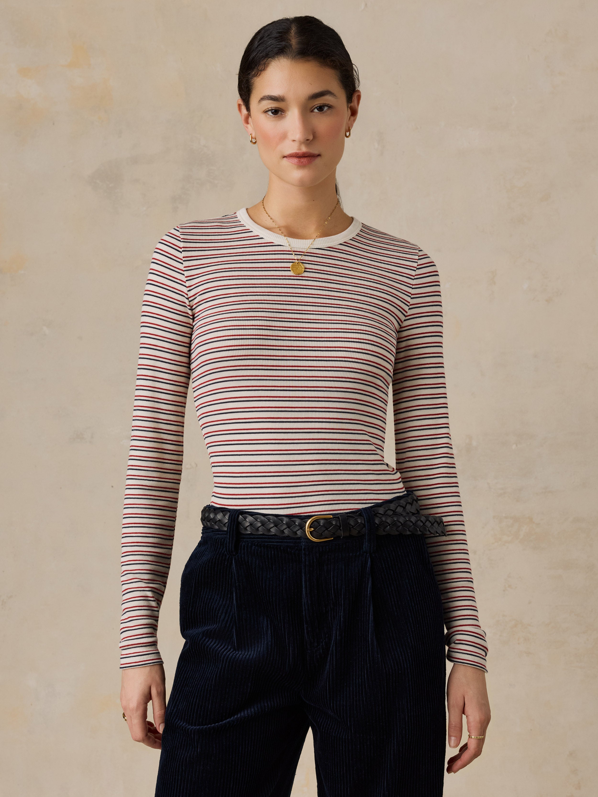 A woman wearing a striped shirt and dark pants