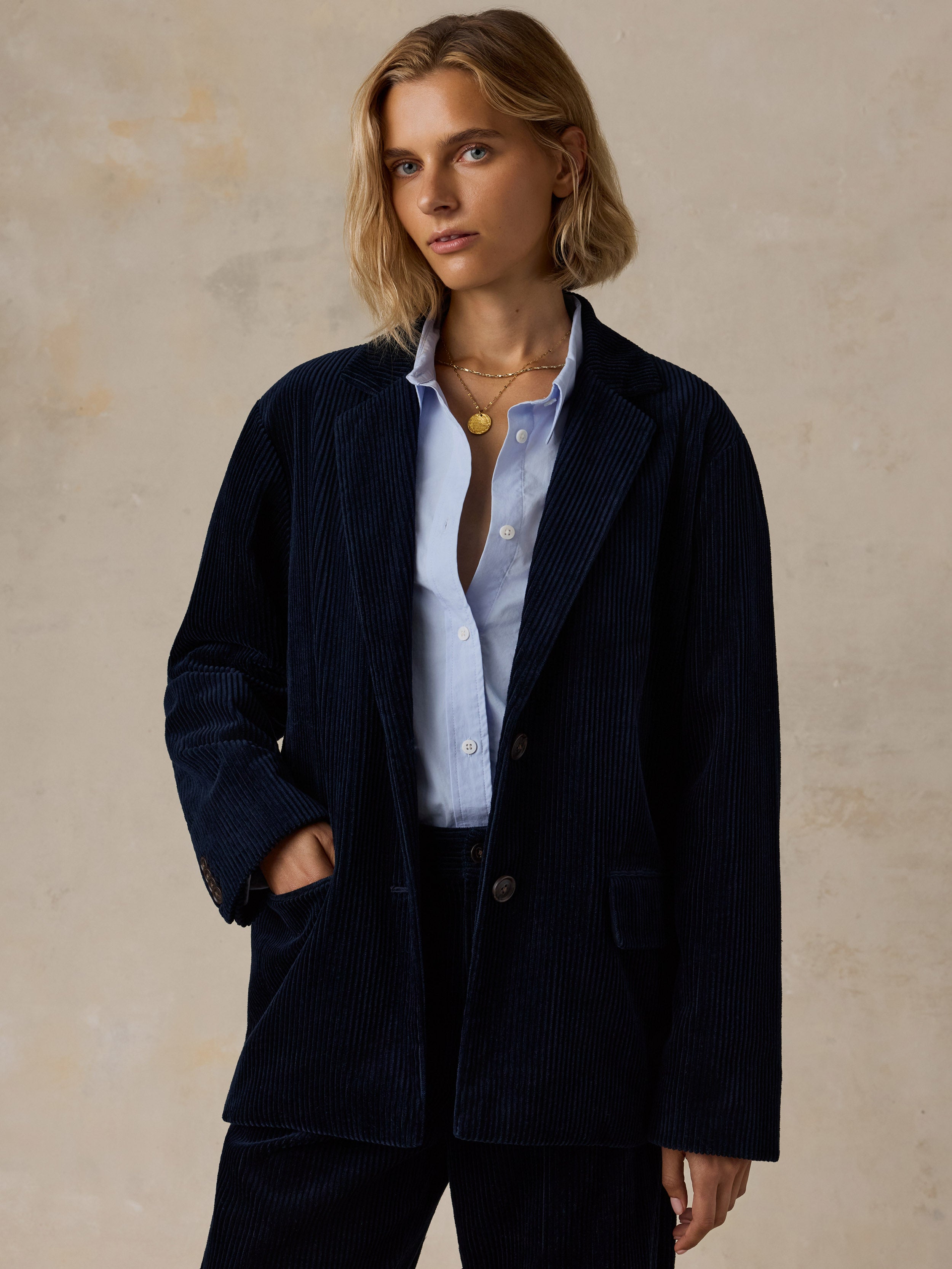 A woman wearing a dark navy blazer over a light blue shirt