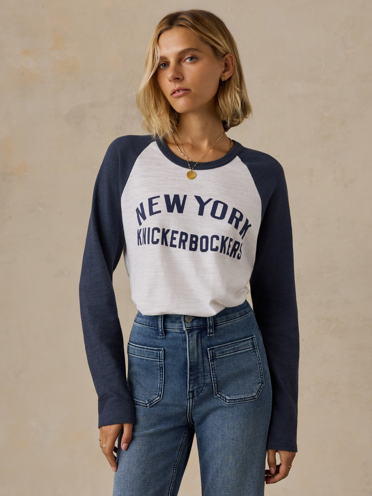 A woman wearing a blue and white NY Knicks baseball tee, image 1 of 6