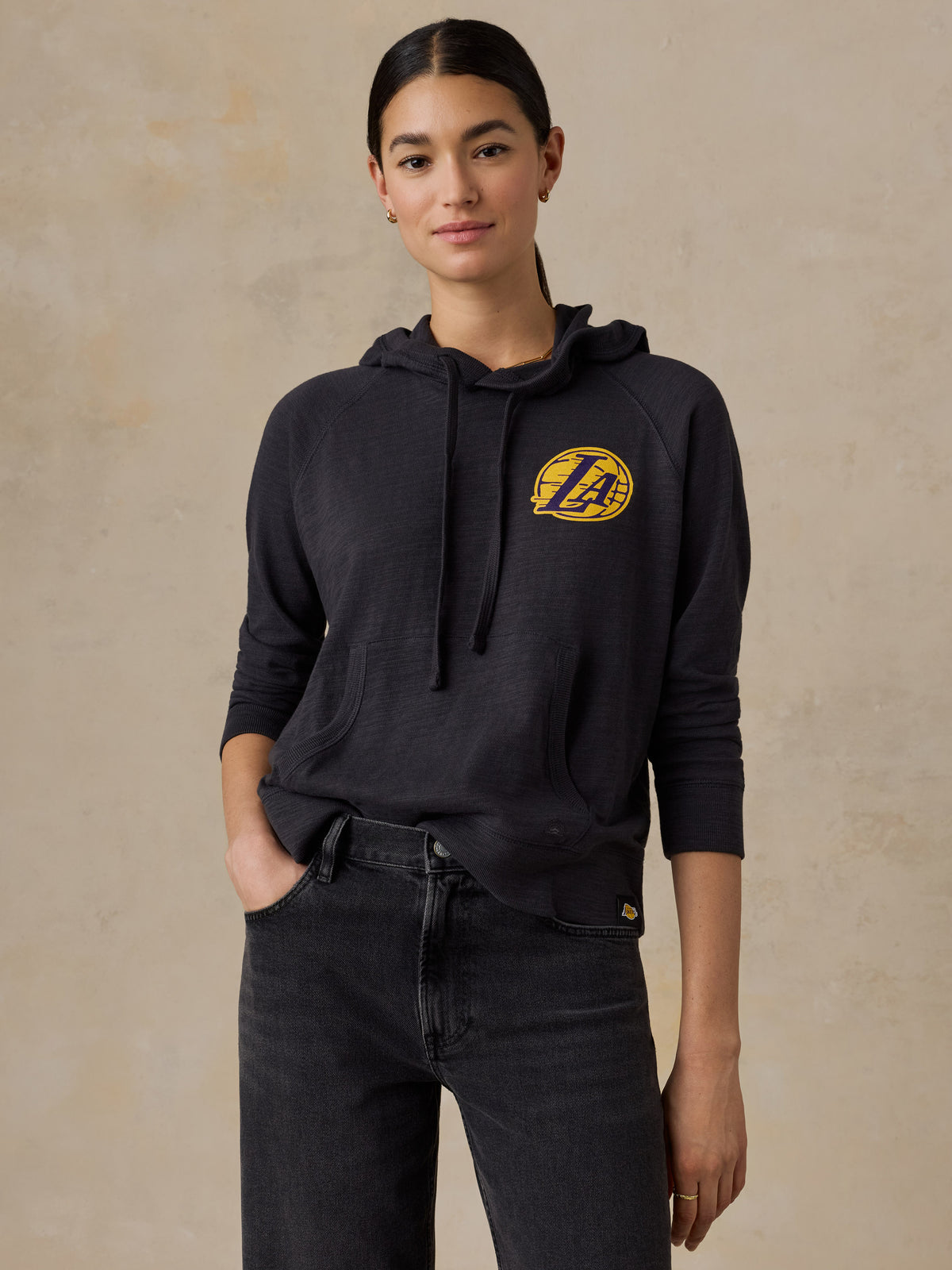 A woman wearing a black LA Lakers hoodie, image 1 of 5