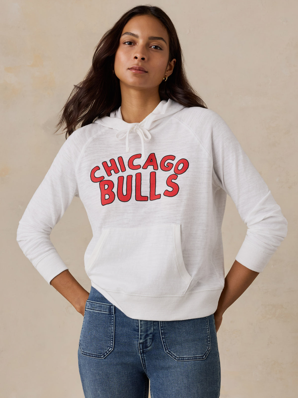A woman wearing a white Chicago Bulls hoodie, image 1 of 5