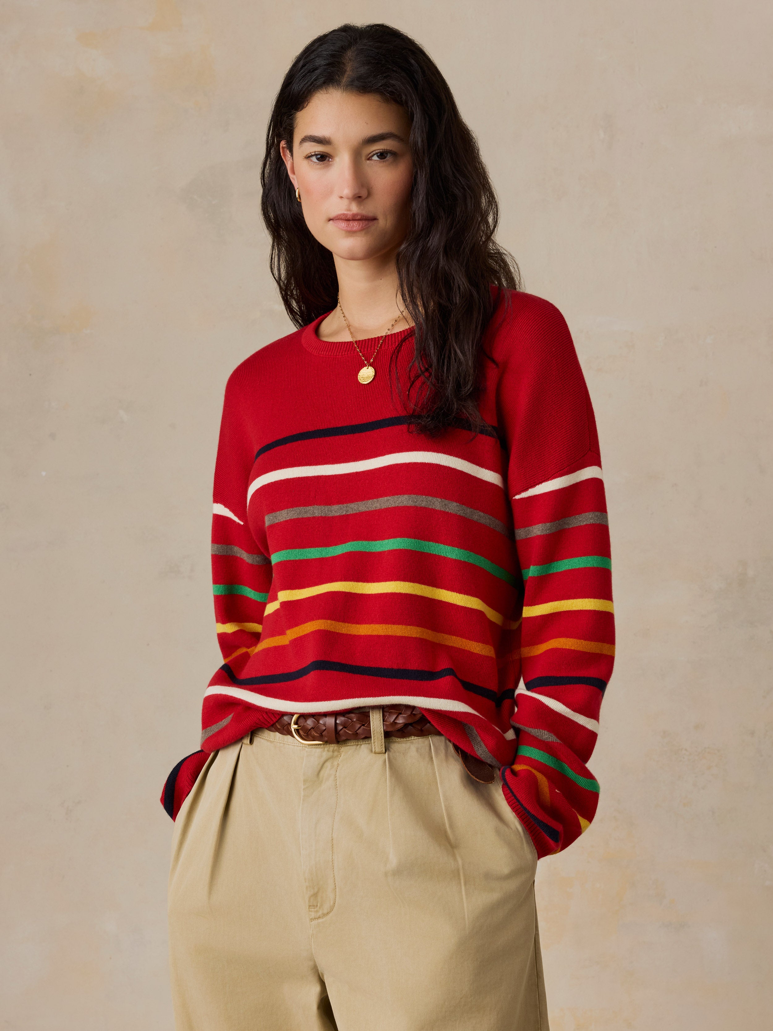 A woman wearing a red striped sweater and chino pants