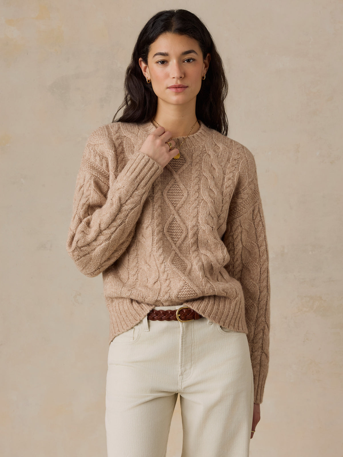 A woman wearing a beige sweater and white pants, image 1 of 5