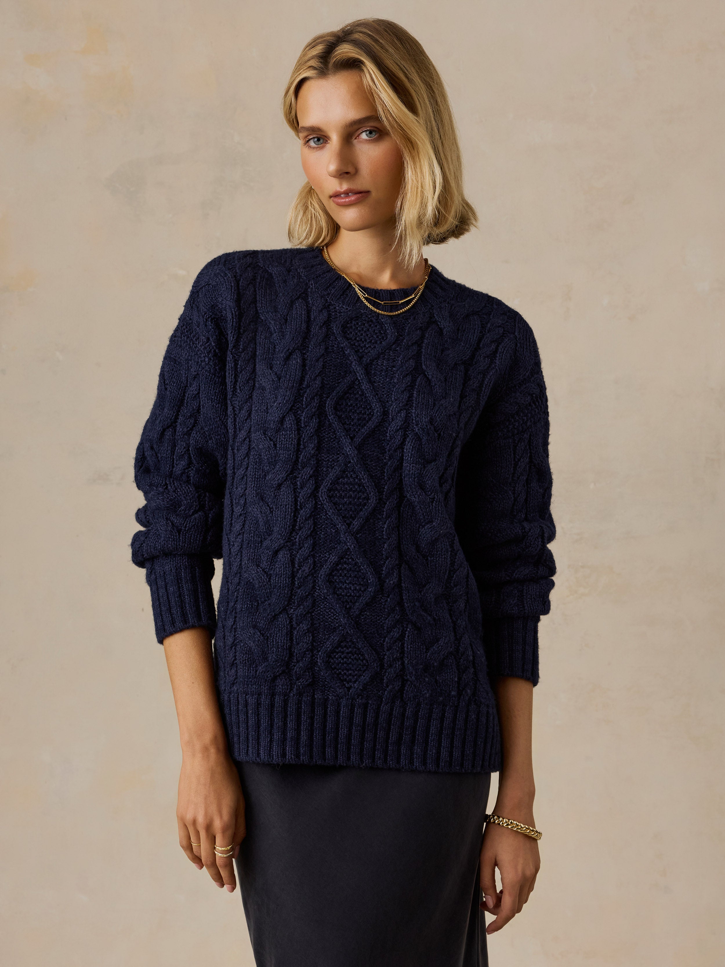 A woman wearing a blue sweater and black skirt