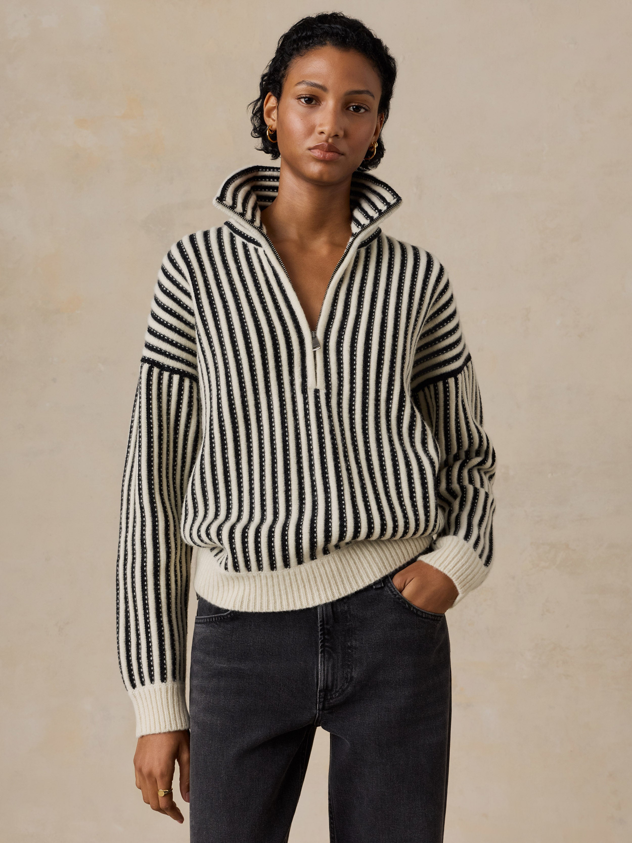 A woman wearing a black and white striped sweater and jeans