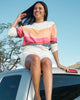 Woman sitting on the roof of a car wearing the sunwashed soleil crewneck sweatshirt.