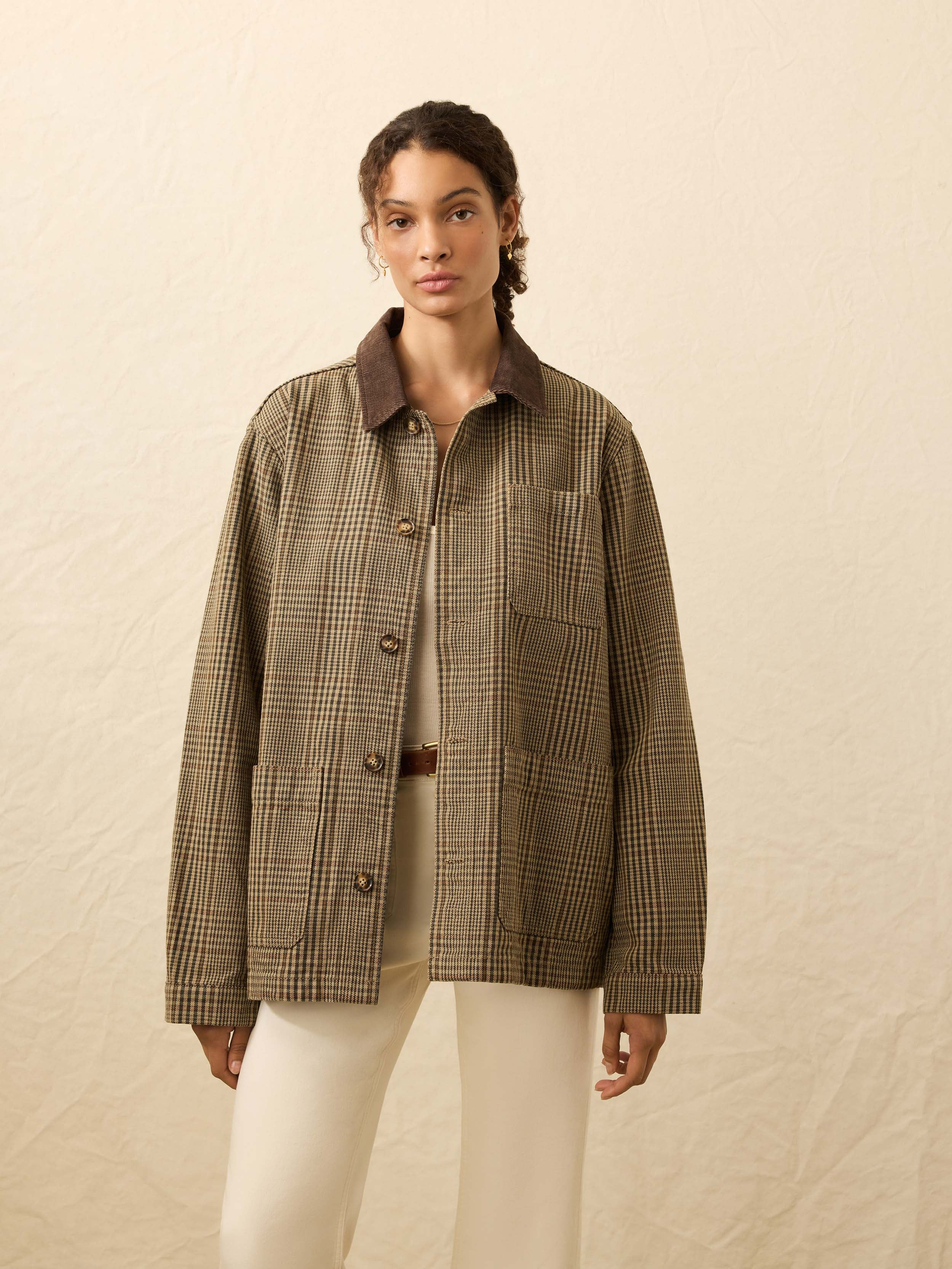 Woman wearing a brown checkered jacket against a beige background