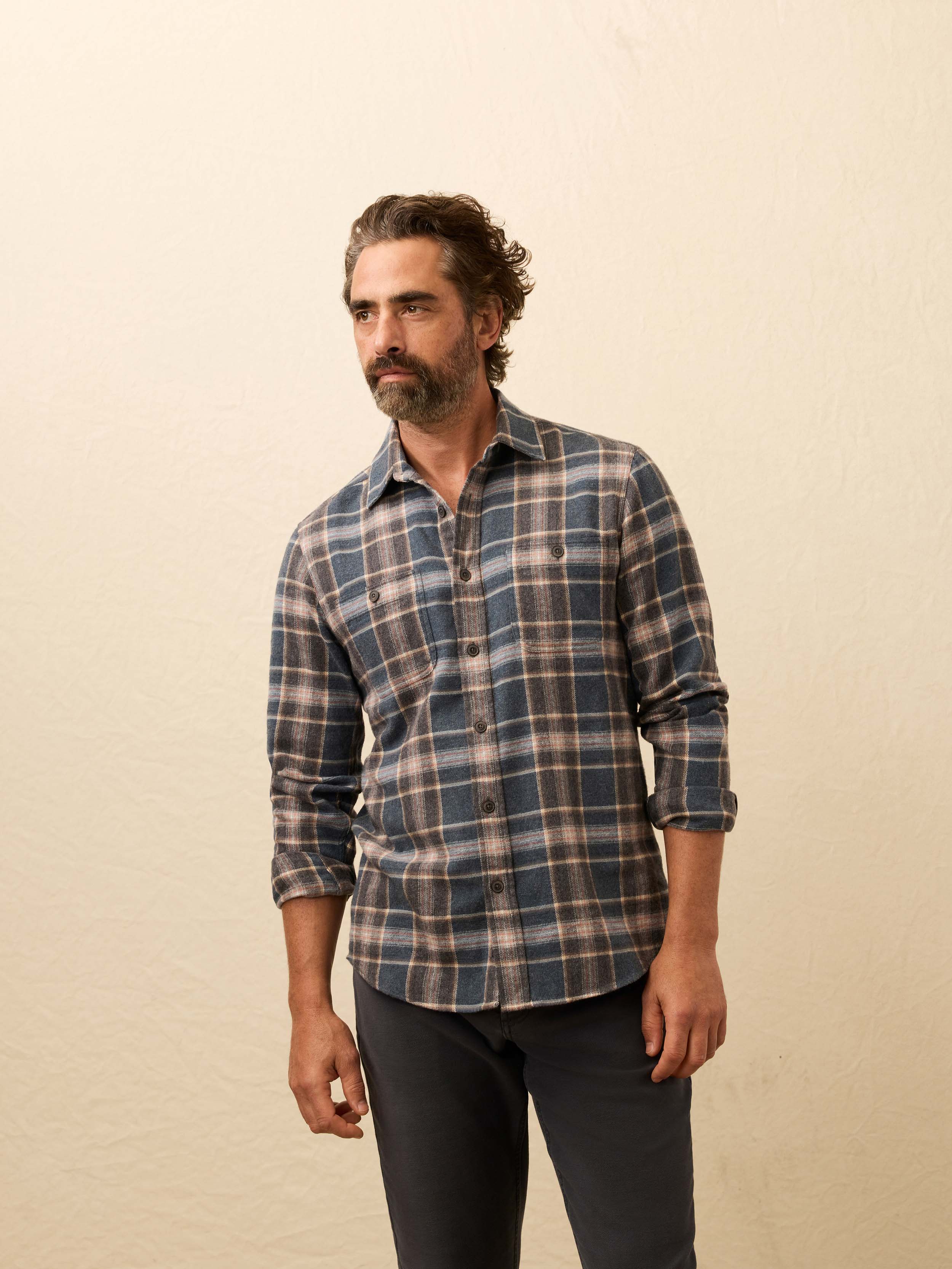 Man wearing a plaid shirt against a beige background