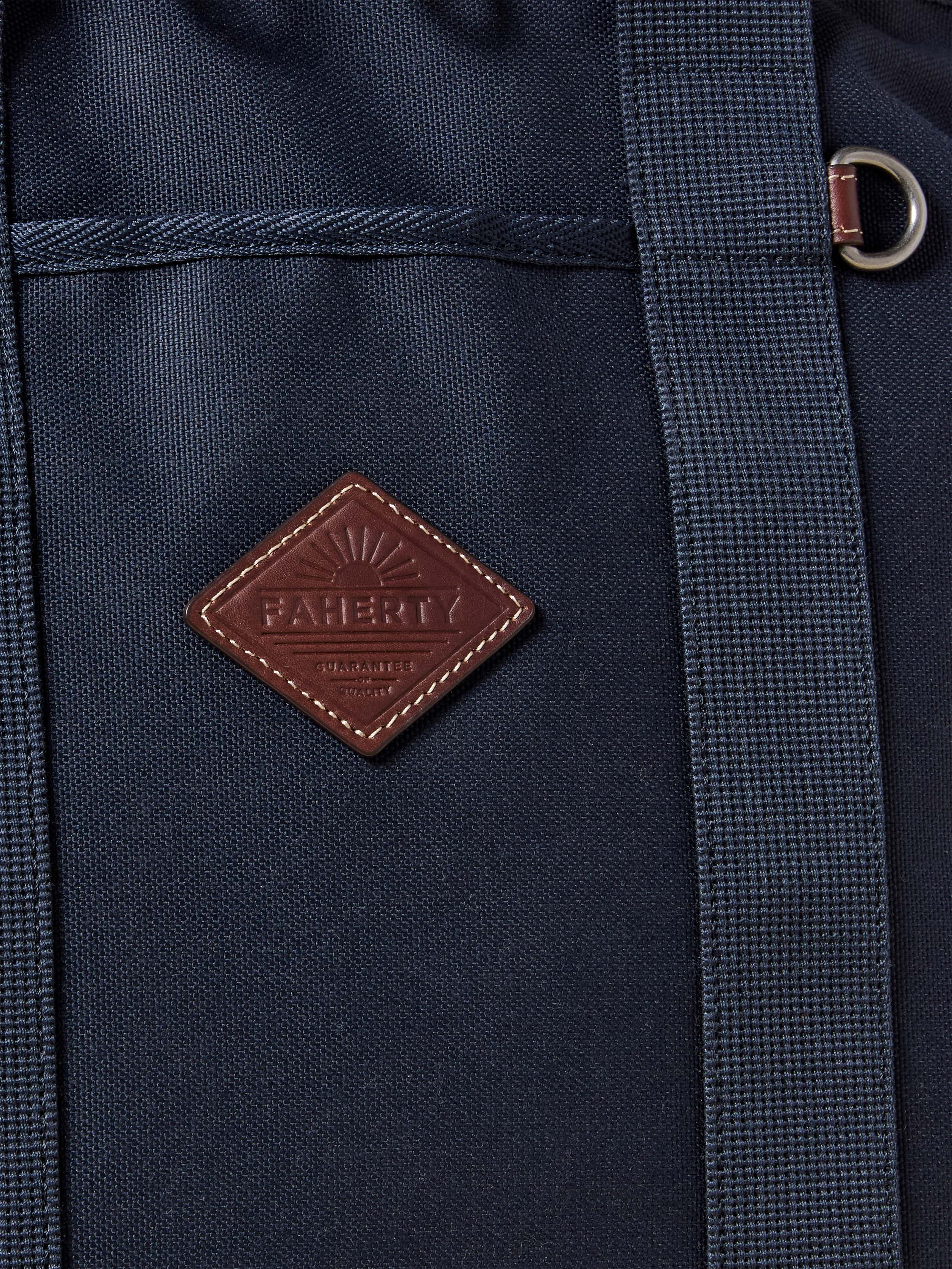 Navy blue backpack with a brown leather patch featuring the Faherty brand logo.