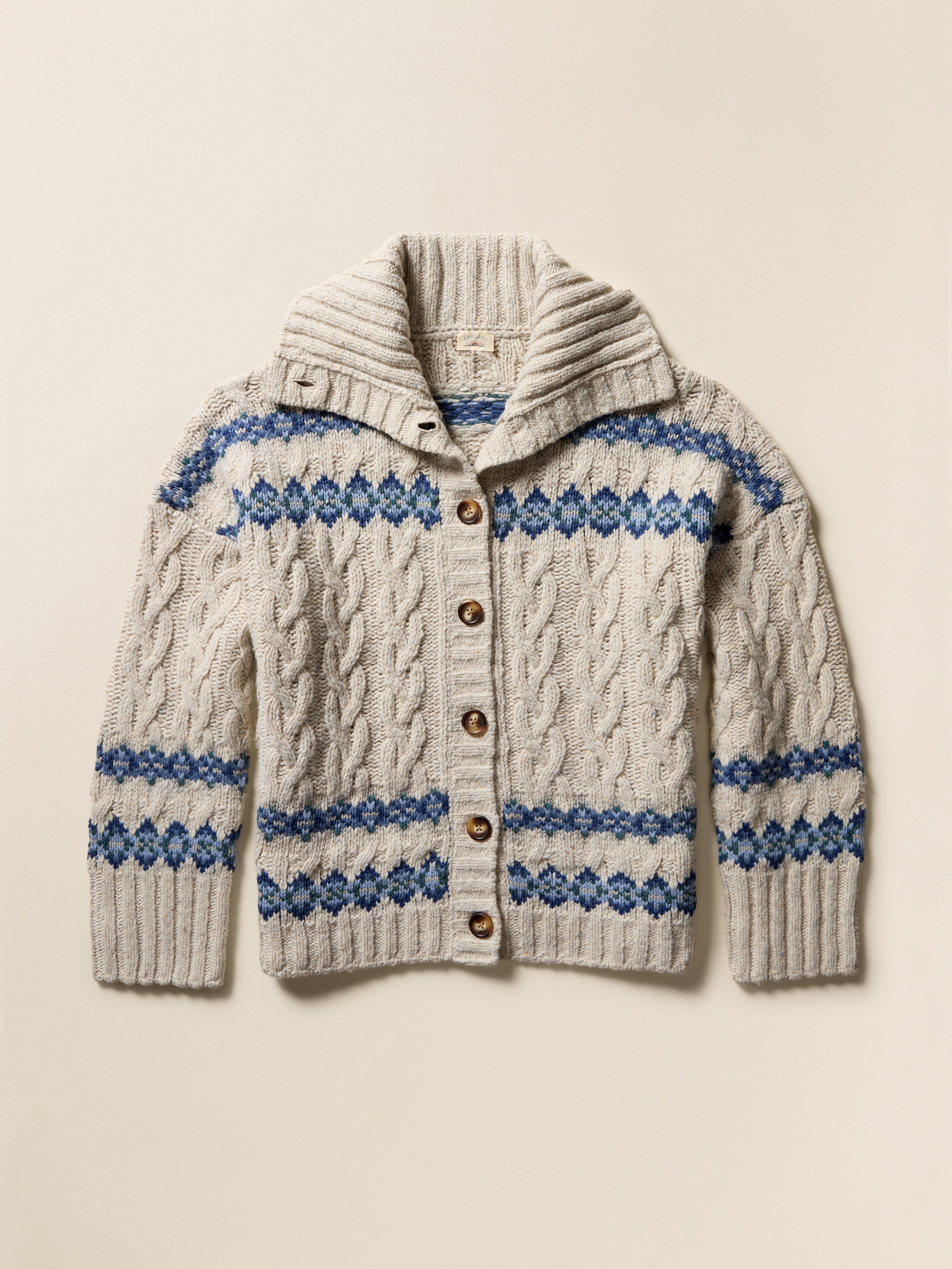 Flat image of a cream-colored knit cardigan with blue fairisle pattern on a beige background