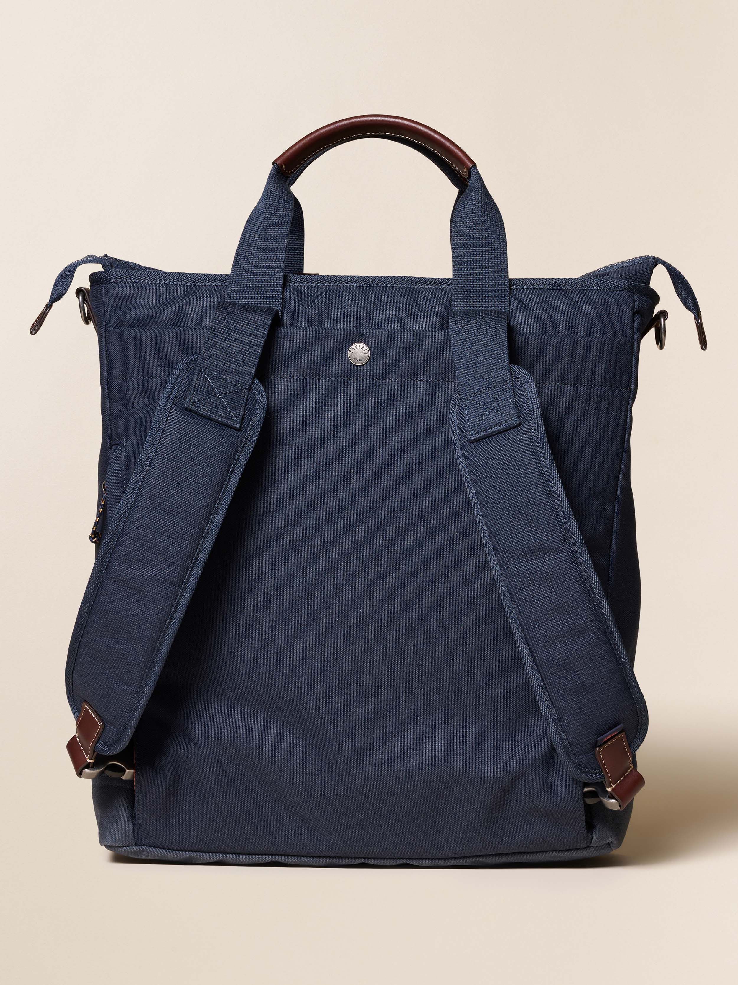 Navy blue backpack against a beige background