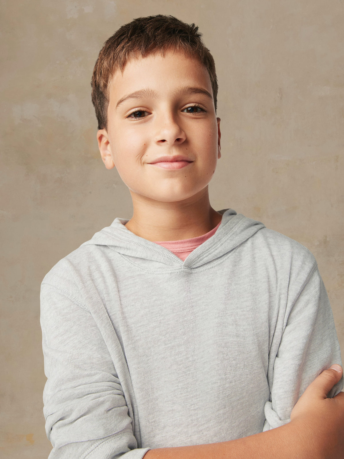 Close up of a boy wearing a grey hoodie, image 4 of 5