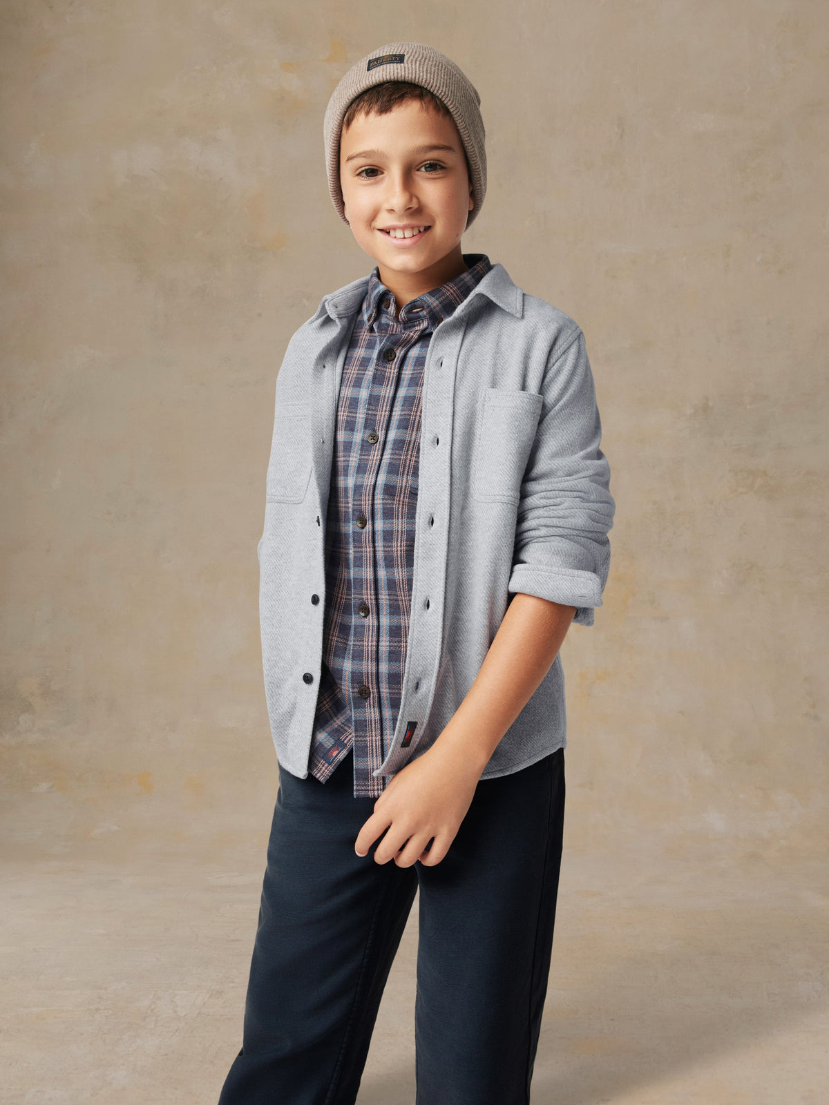 Close up of a child wearing a grey button up shirt and black pants, image 2 of 7