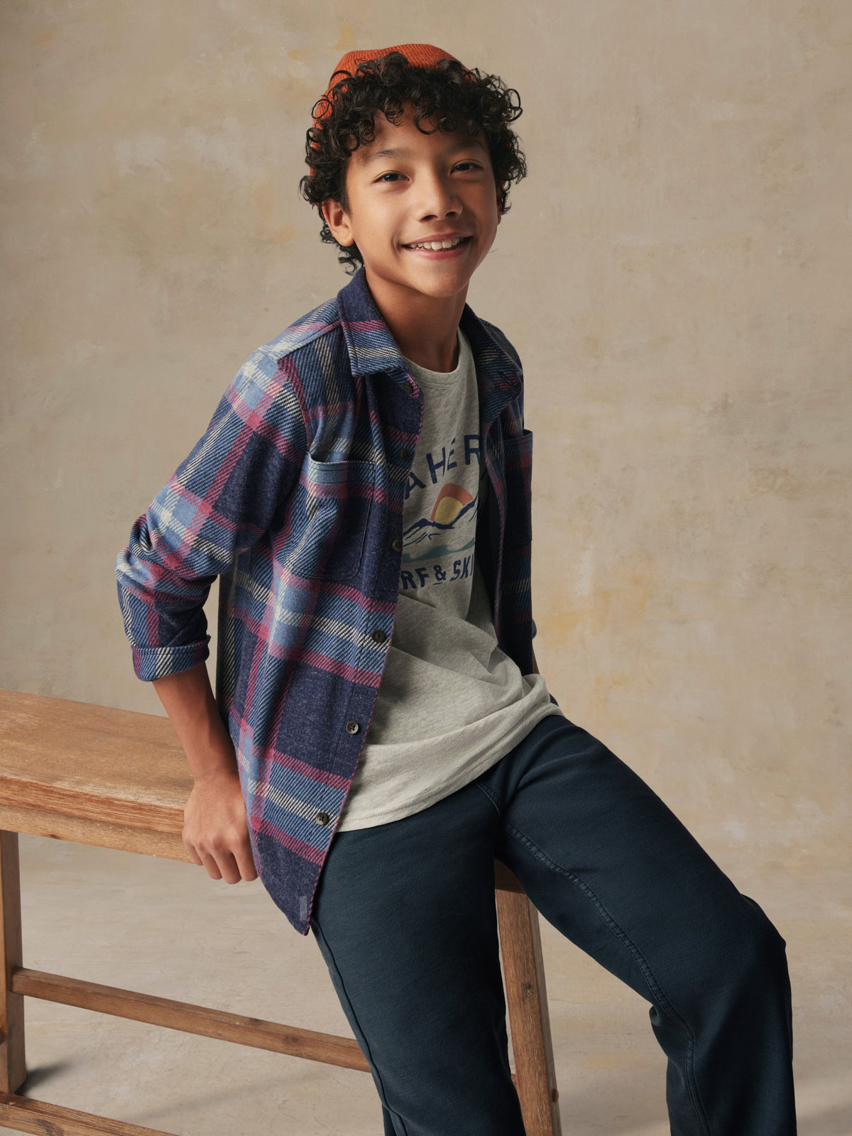 Close up of a child wearing a plaid button up shirt and black pants, image 3 of 6