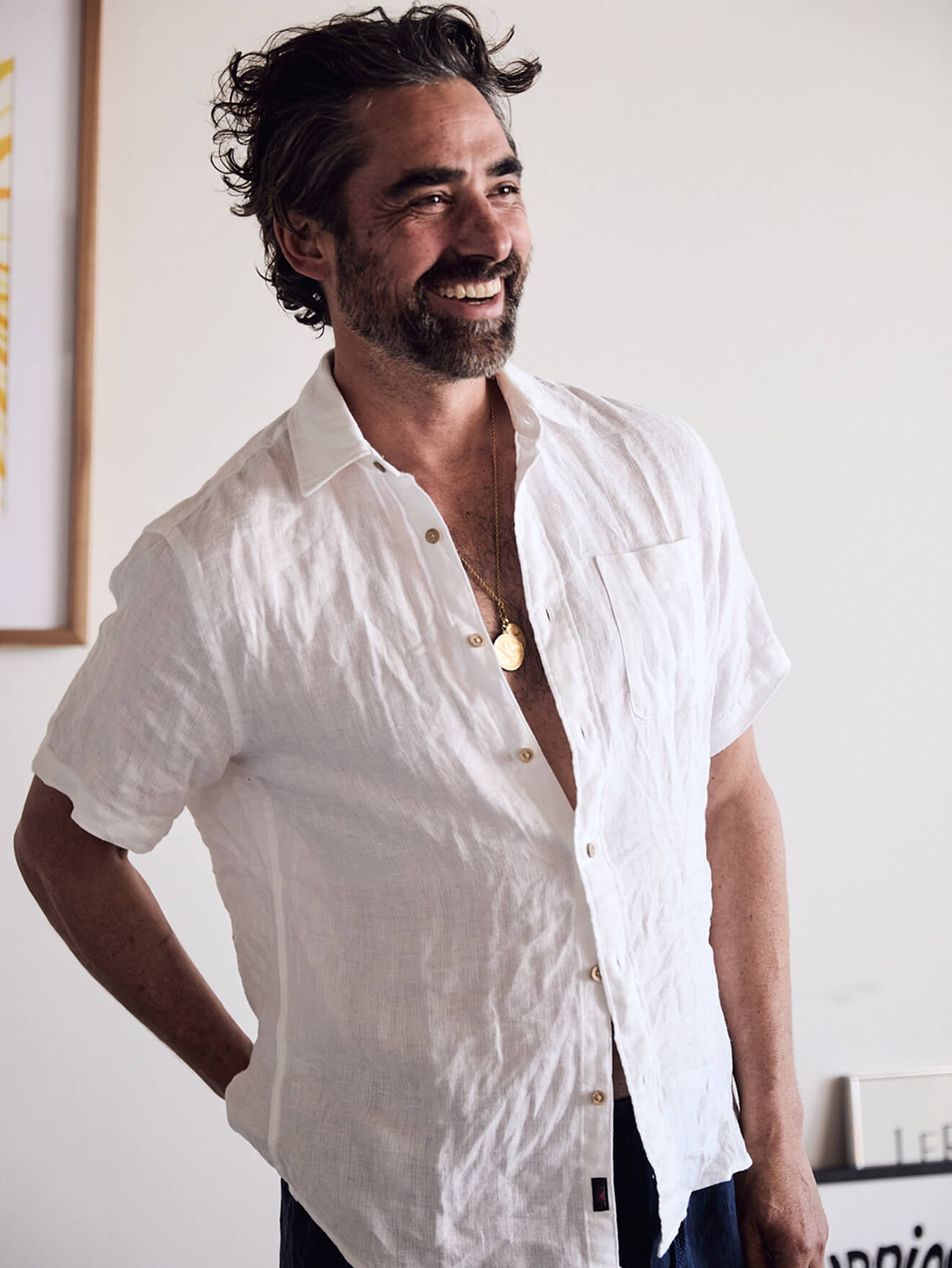 Male model wearing a white linen shirt and blue linen shorts