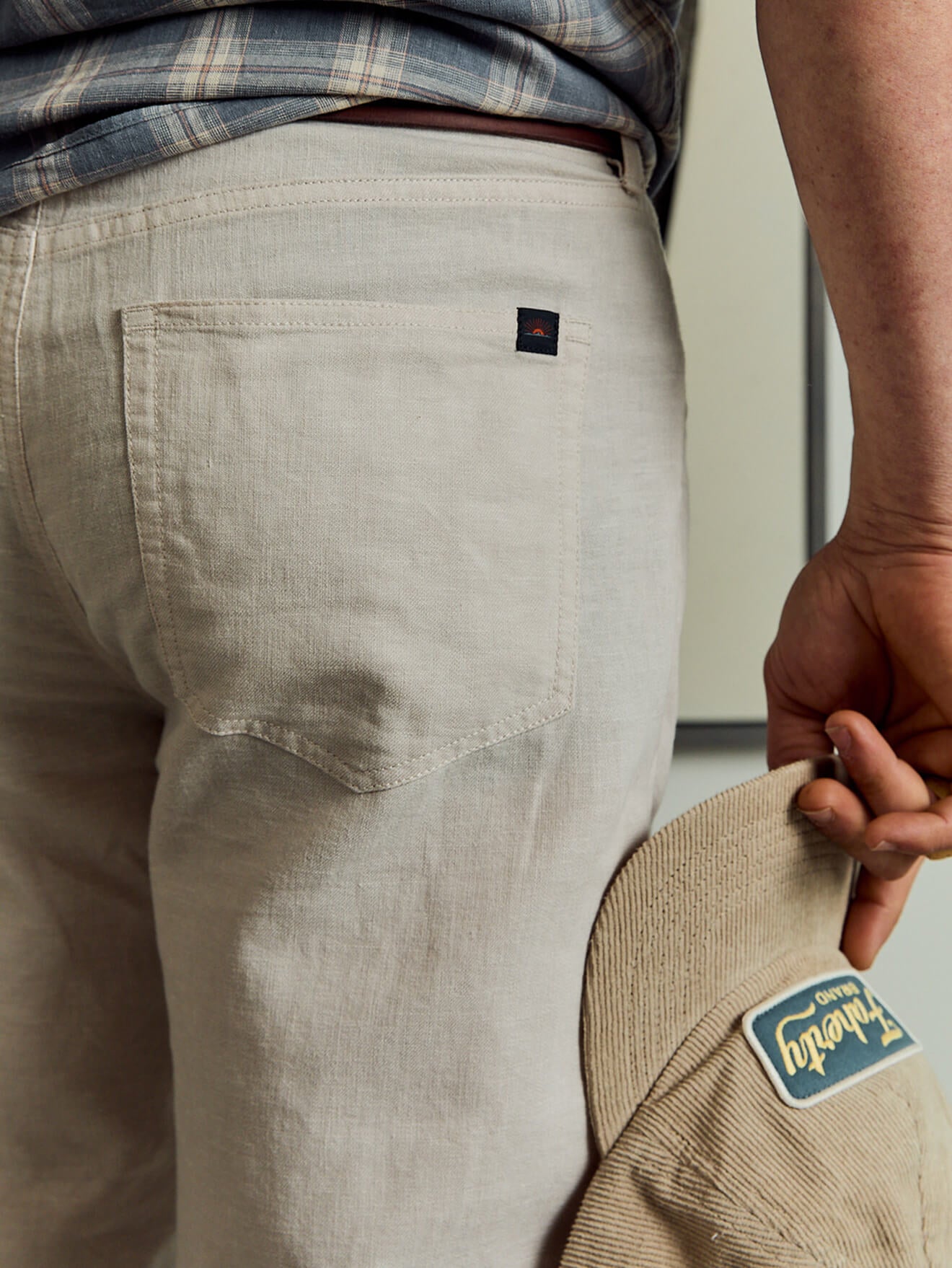 A close up of a male model wearing white movement linen pants