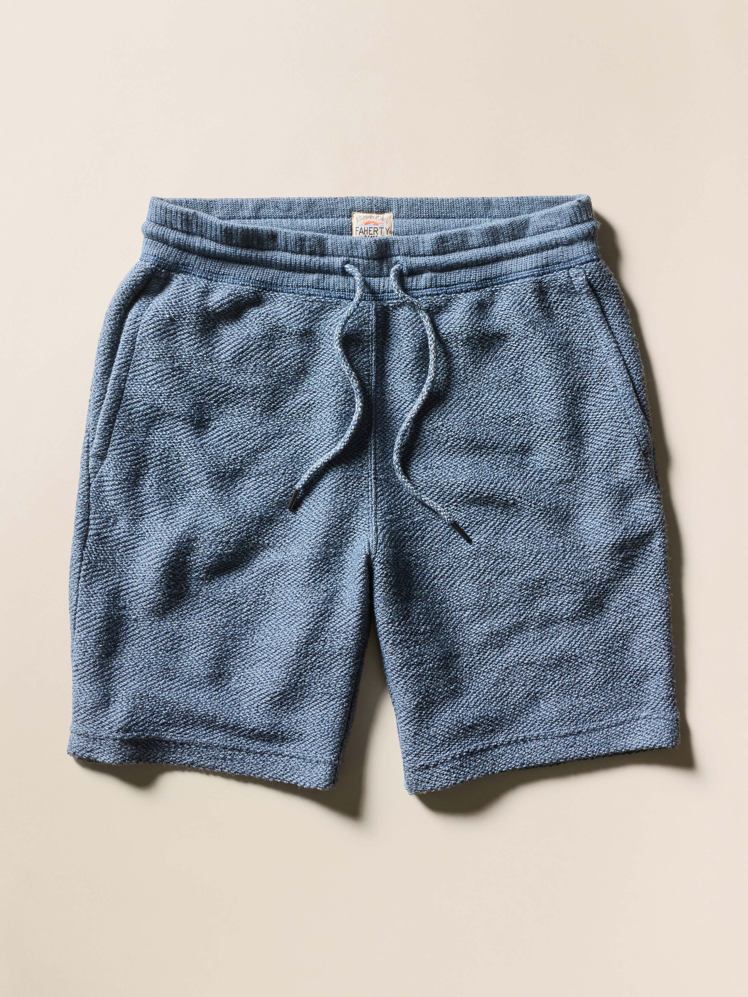 Blue shorts against a beige background