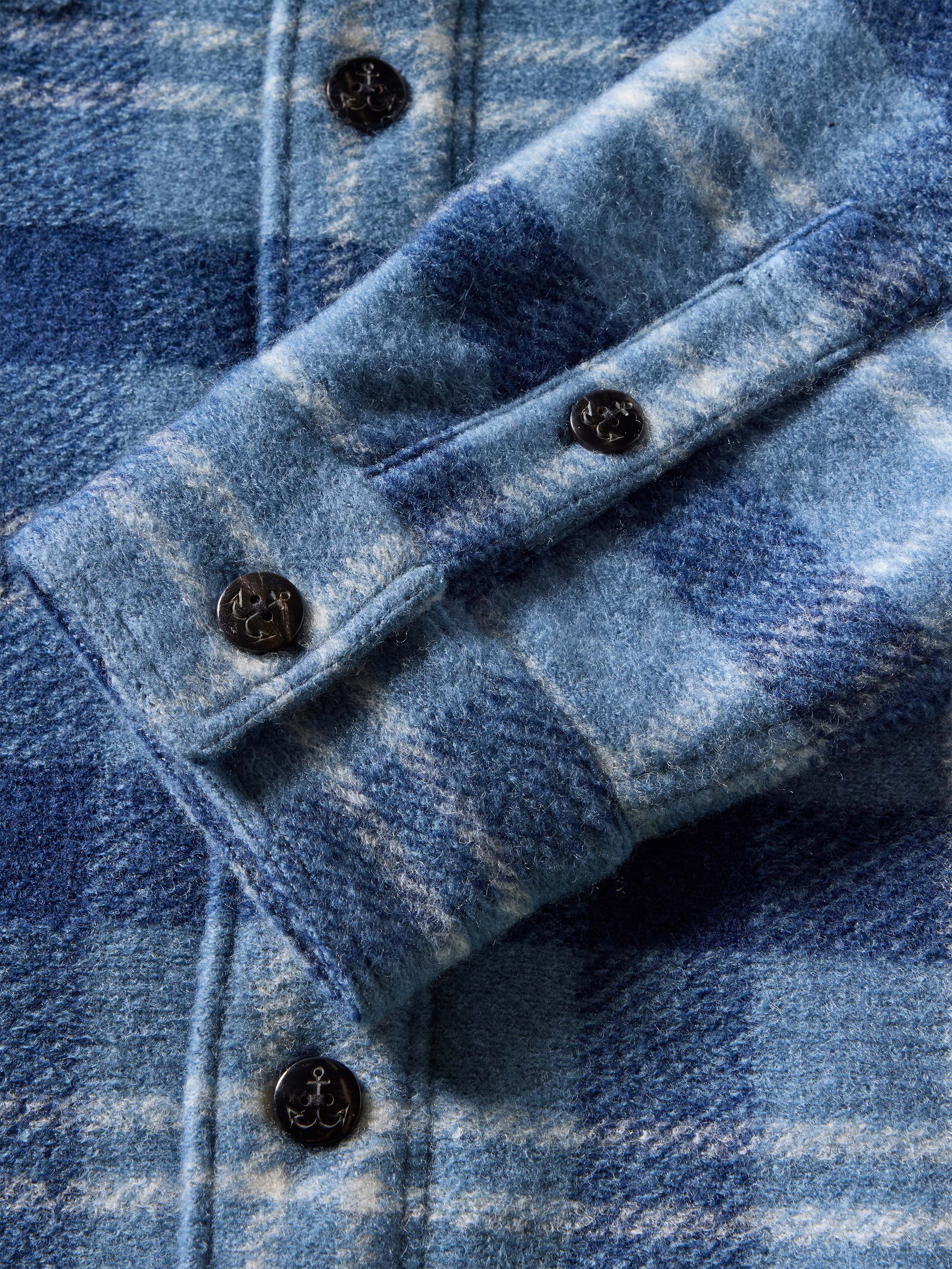 Close-up of a blue plaid flannel shirt jacket with buttons
