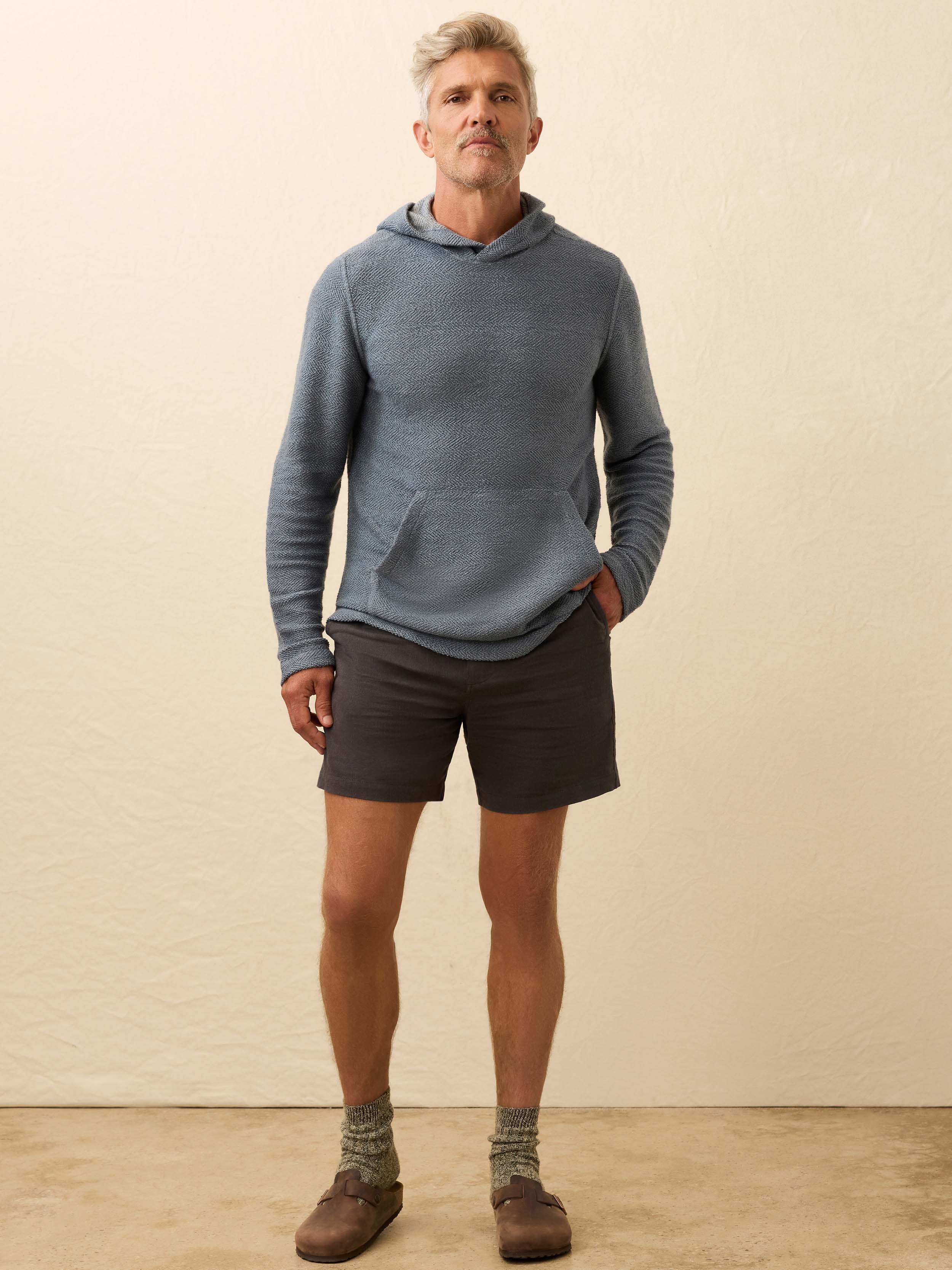 Man wearing a blue hoodie against a beige background