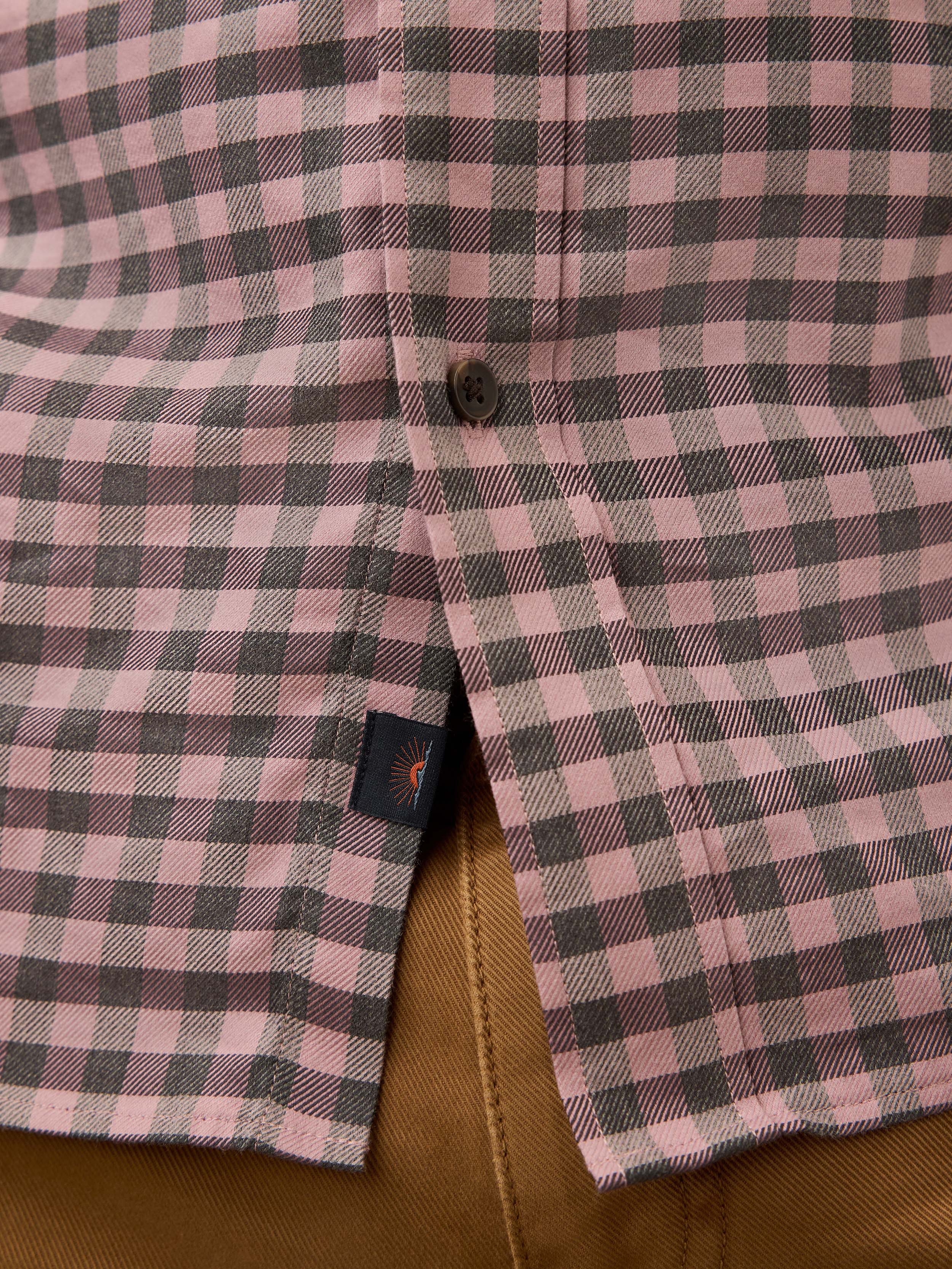 Close-up of a pink and gray gingham shirt with a Faherty brand label