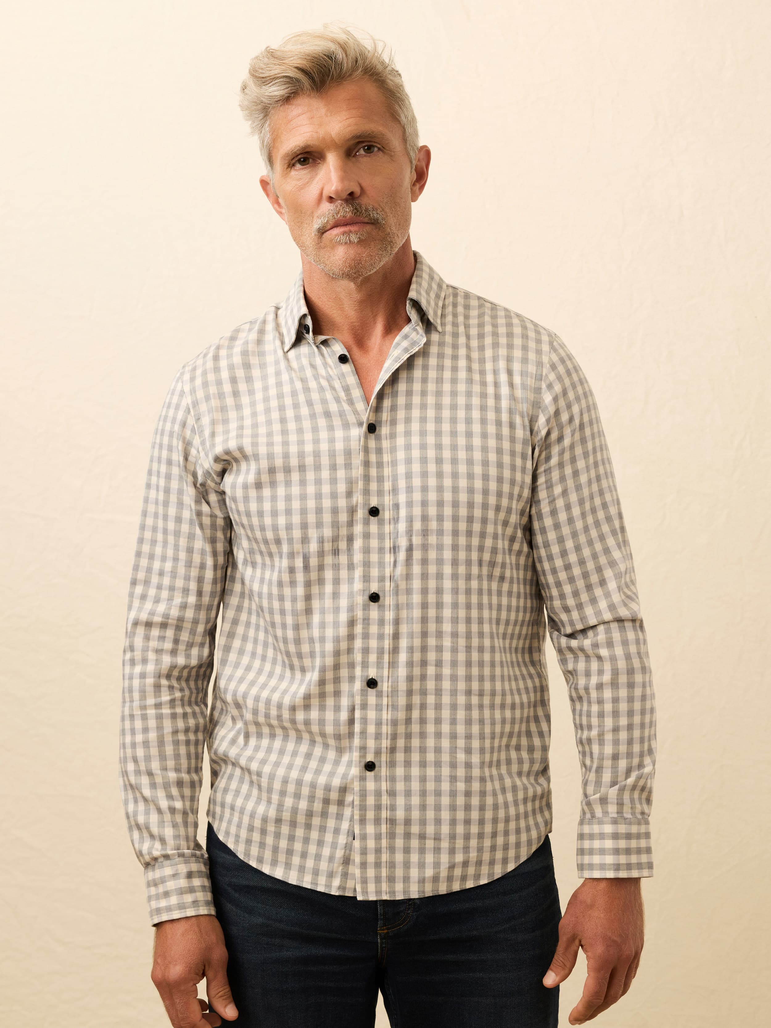 Man wearing a checkered shirt against a beige background